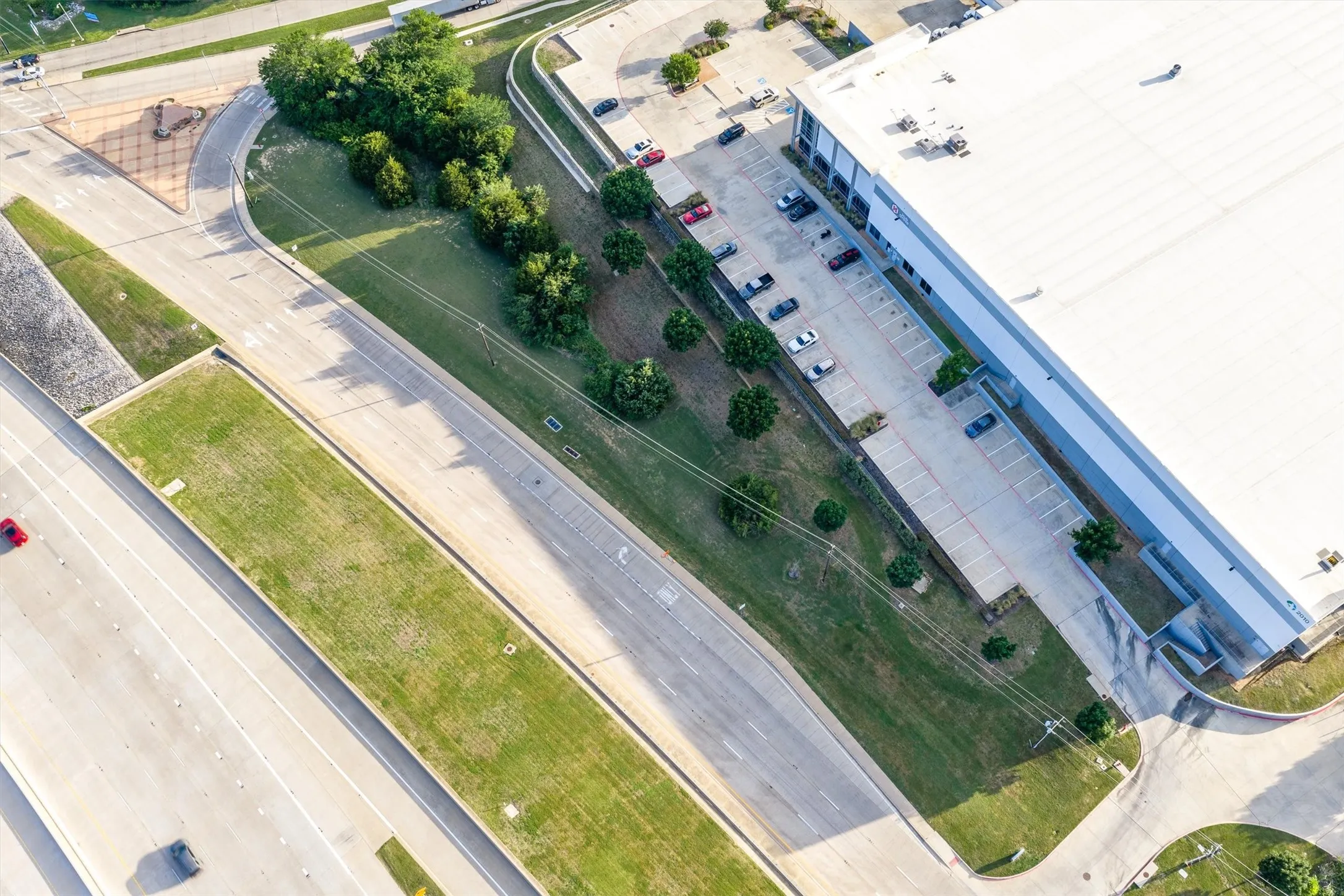 Industrial building featuring a white roof, blue-grey siding, and a paved parking lot