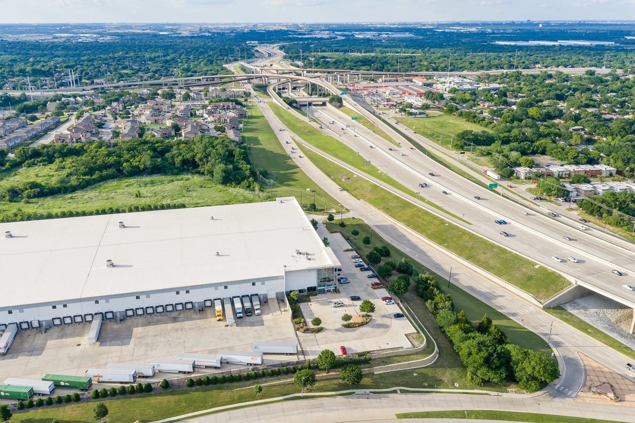 Large industrial building with a white roof and multiple loading docks