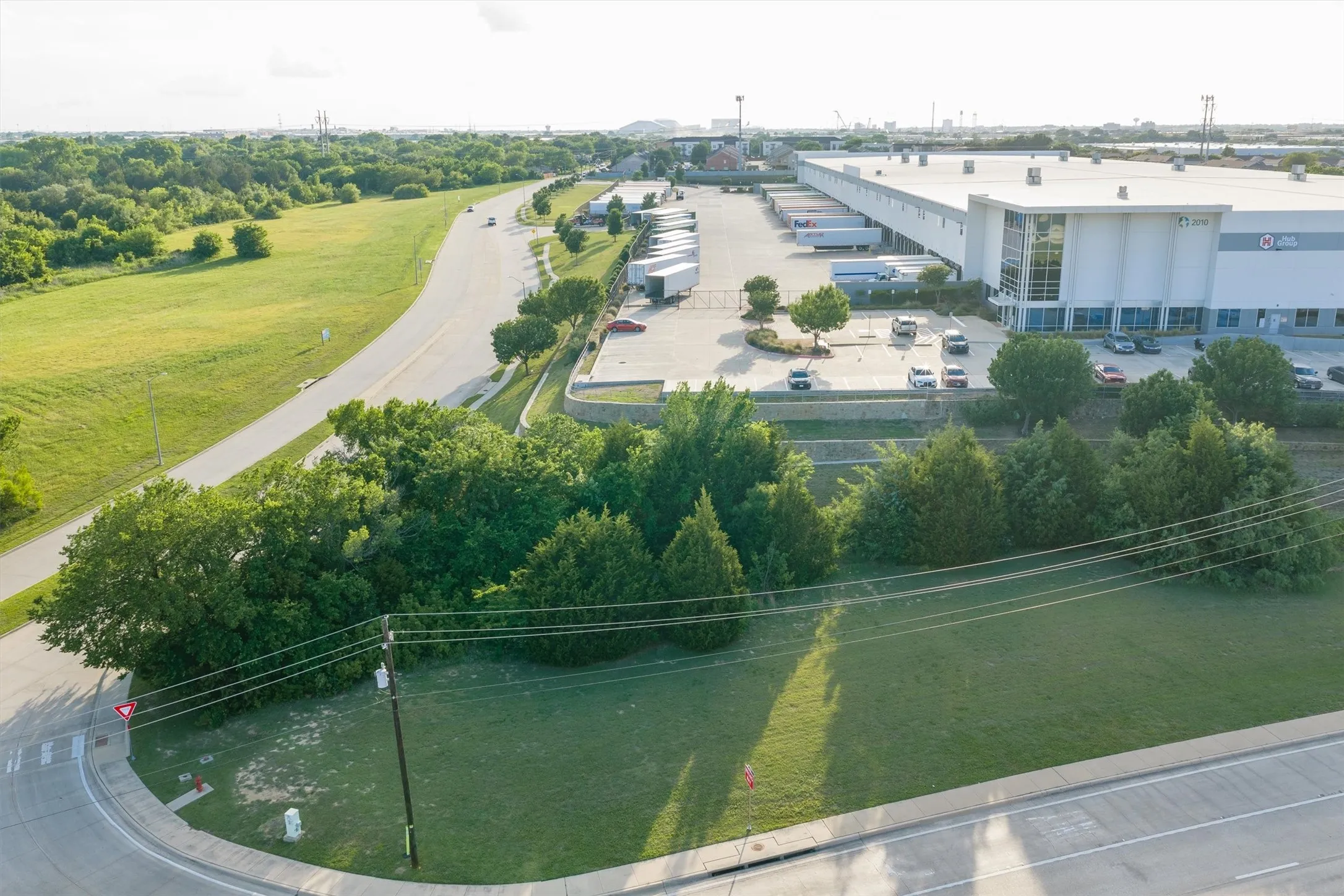 Large commercial building featuring an expansive loading dock area, ample parking, and an office facade with extensive glazing