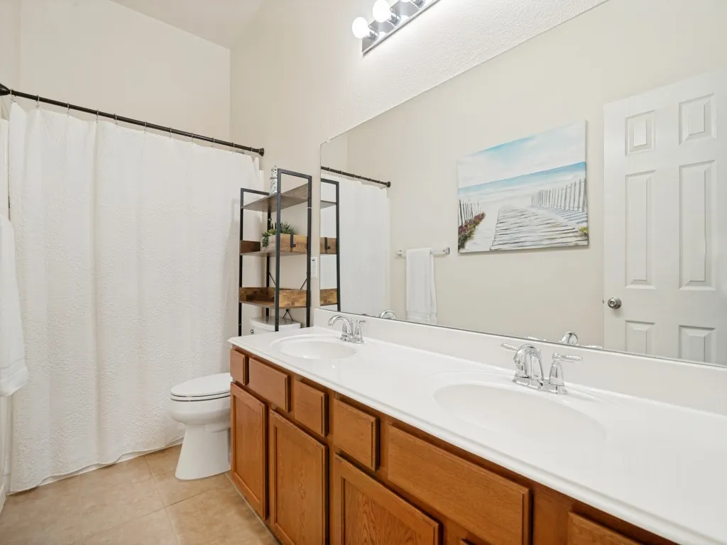 Bathroom featuring a double vanity with wood cabinetry and dual undermount sinks