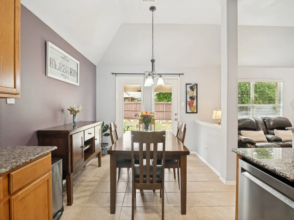 Dining area featuring a vaulted ceiling, tile flooring, and direct access to the outdoor space