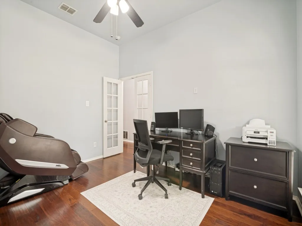 Room featuring hardwood flooring, light-toned walls, and a ceiling fan