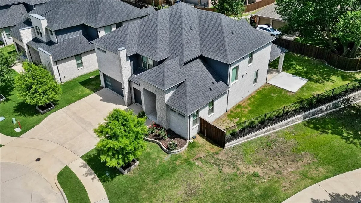 Modern residence with a multi-level roofline, featuring light-colored brick and dark trim