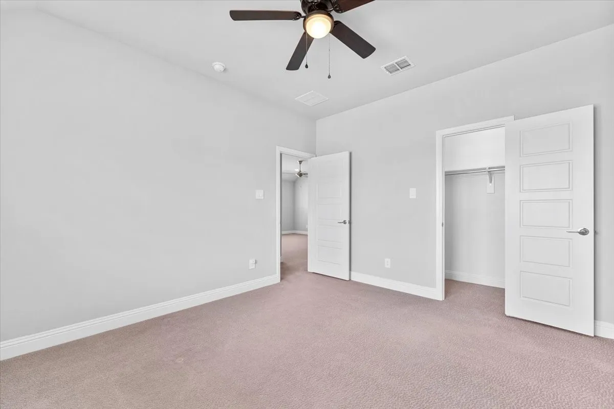 Spacious room featuring neutral carpeting and light-toned walls