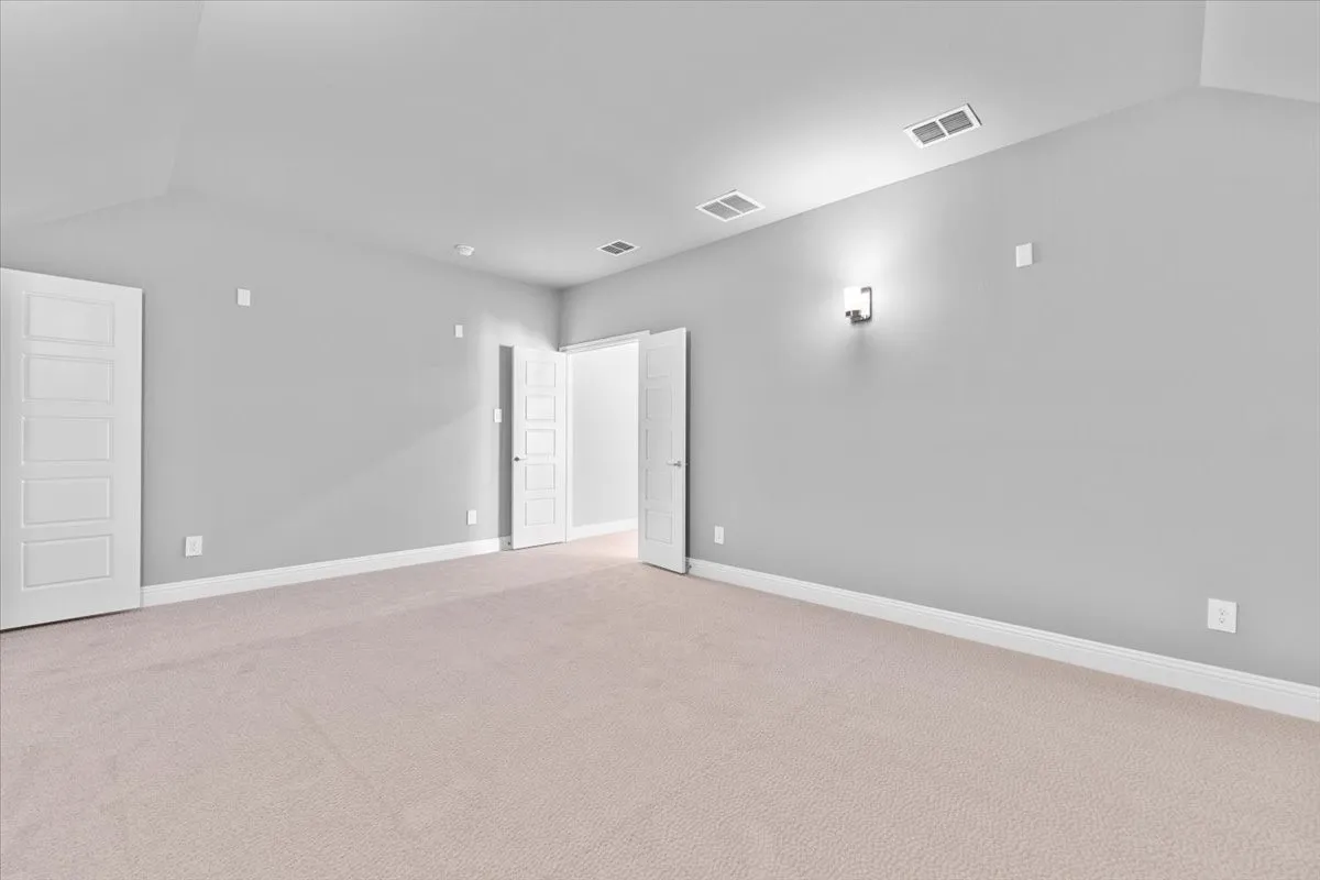 Spacious room with light-colored carpeting, light gray walls, and white trim