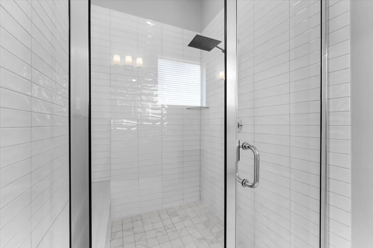 Walk-in shower with clear glass enclosure and chrome hardware