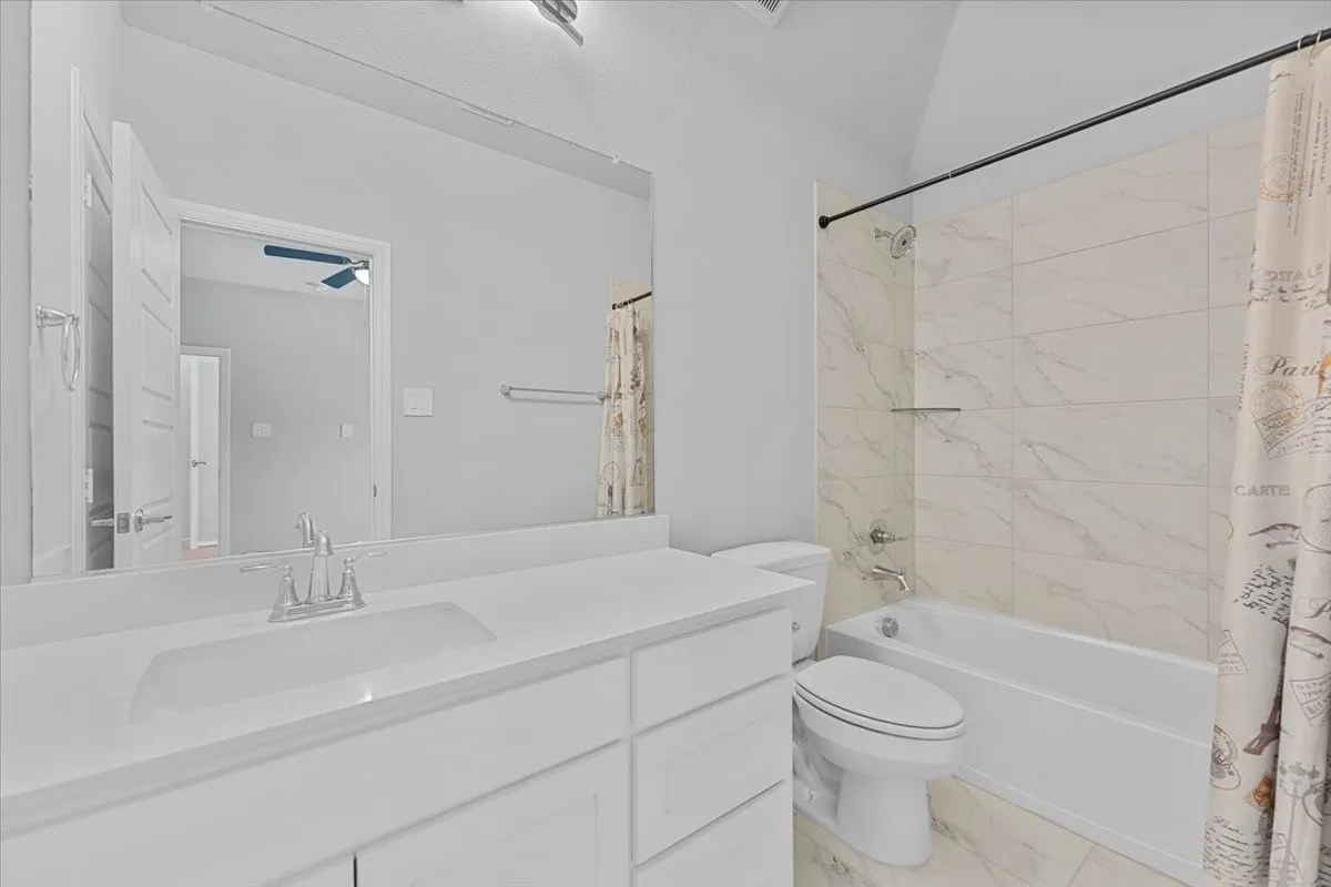 Bathroom featuring a single vanity with an integrated sink, polished chrome faucet, and a large wall-mounted mirror