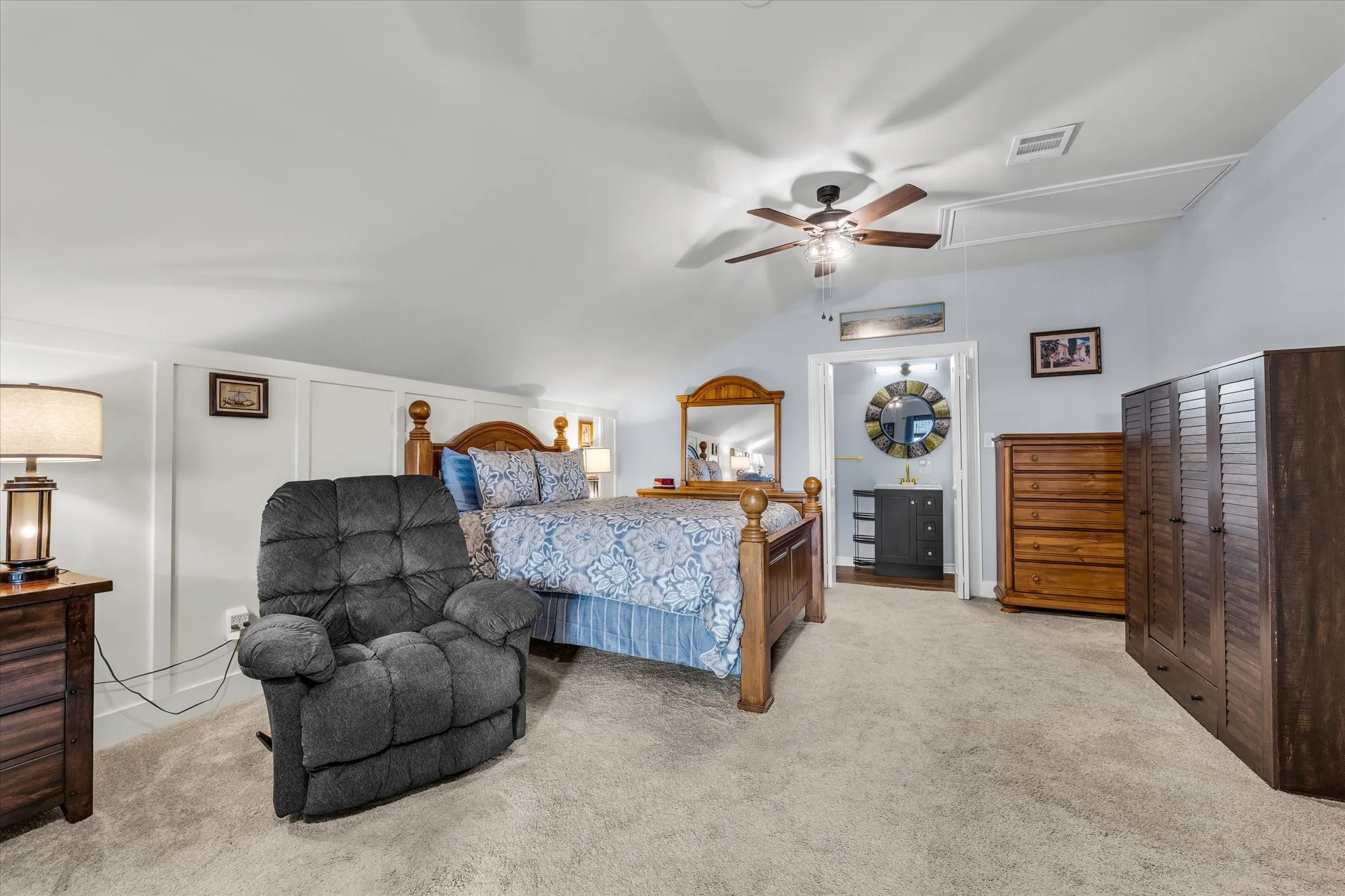 Spacious room with sloped ceilings and light-colored carpeting