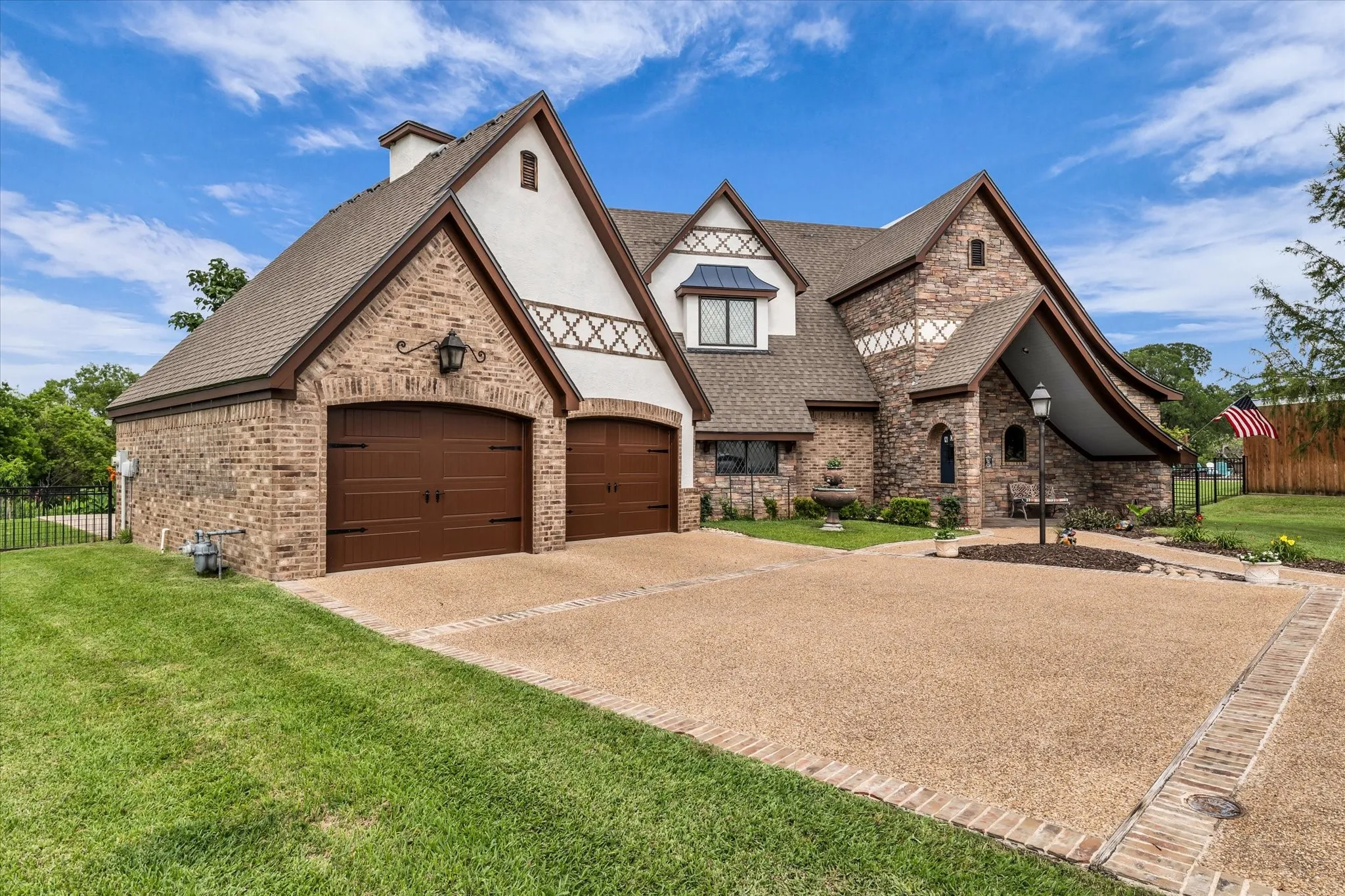 Stately multi-gabled exterior featuring brick and stucco finishes