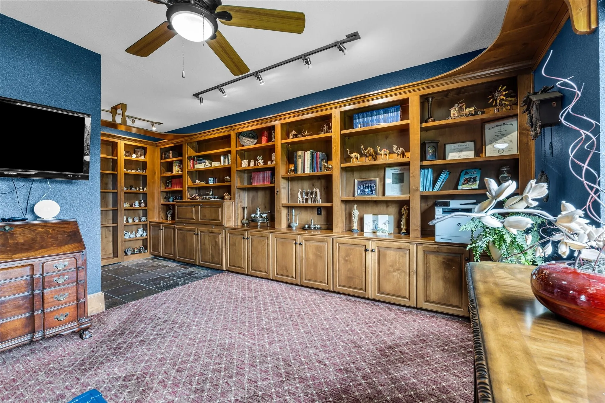 Custom built-in wood shelving and cabinetry with track lighting