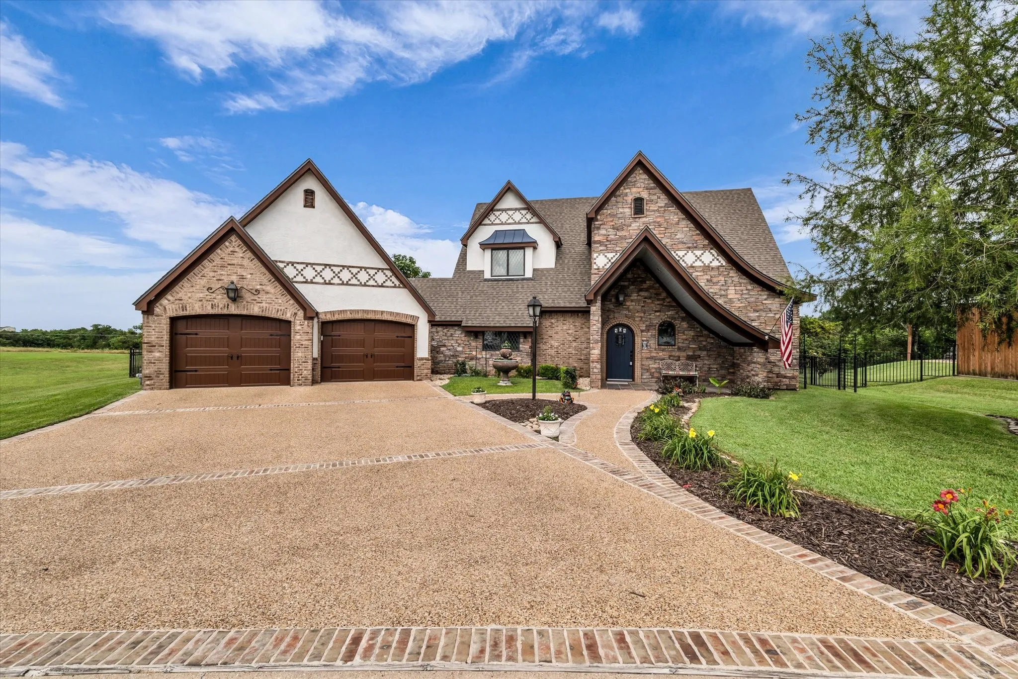 Stone and stucco exterior featuring multiple gables and a prominent arched entry