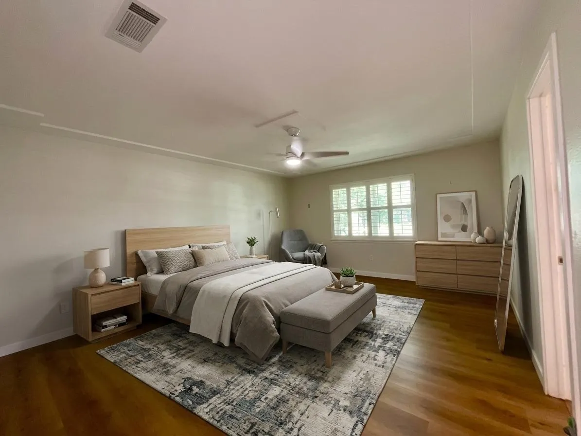 Spacious room featuring wood-finish flooring, a vaulted ceiling, and a ceiling fan