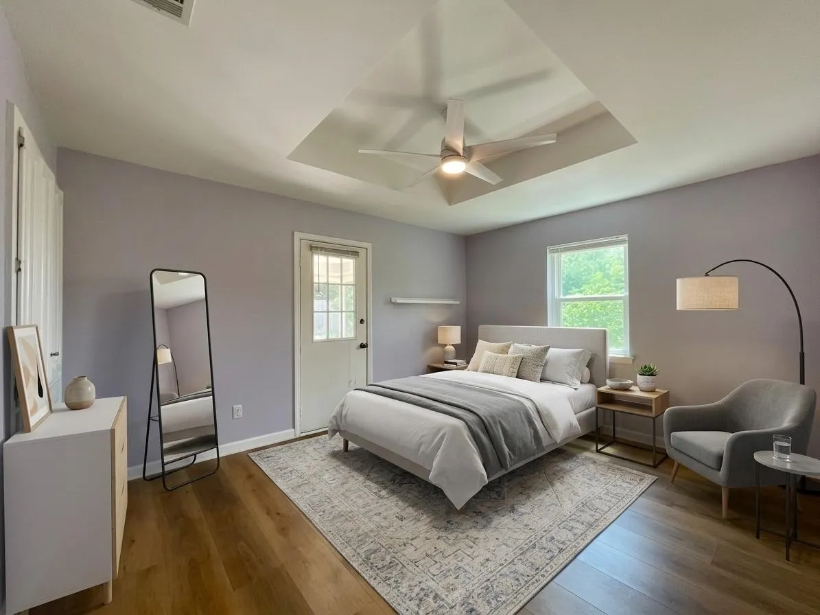 Spacious room featuring wood-finish flooring, a recessed ceiling with a contemporary fan, and a light-filtering window
