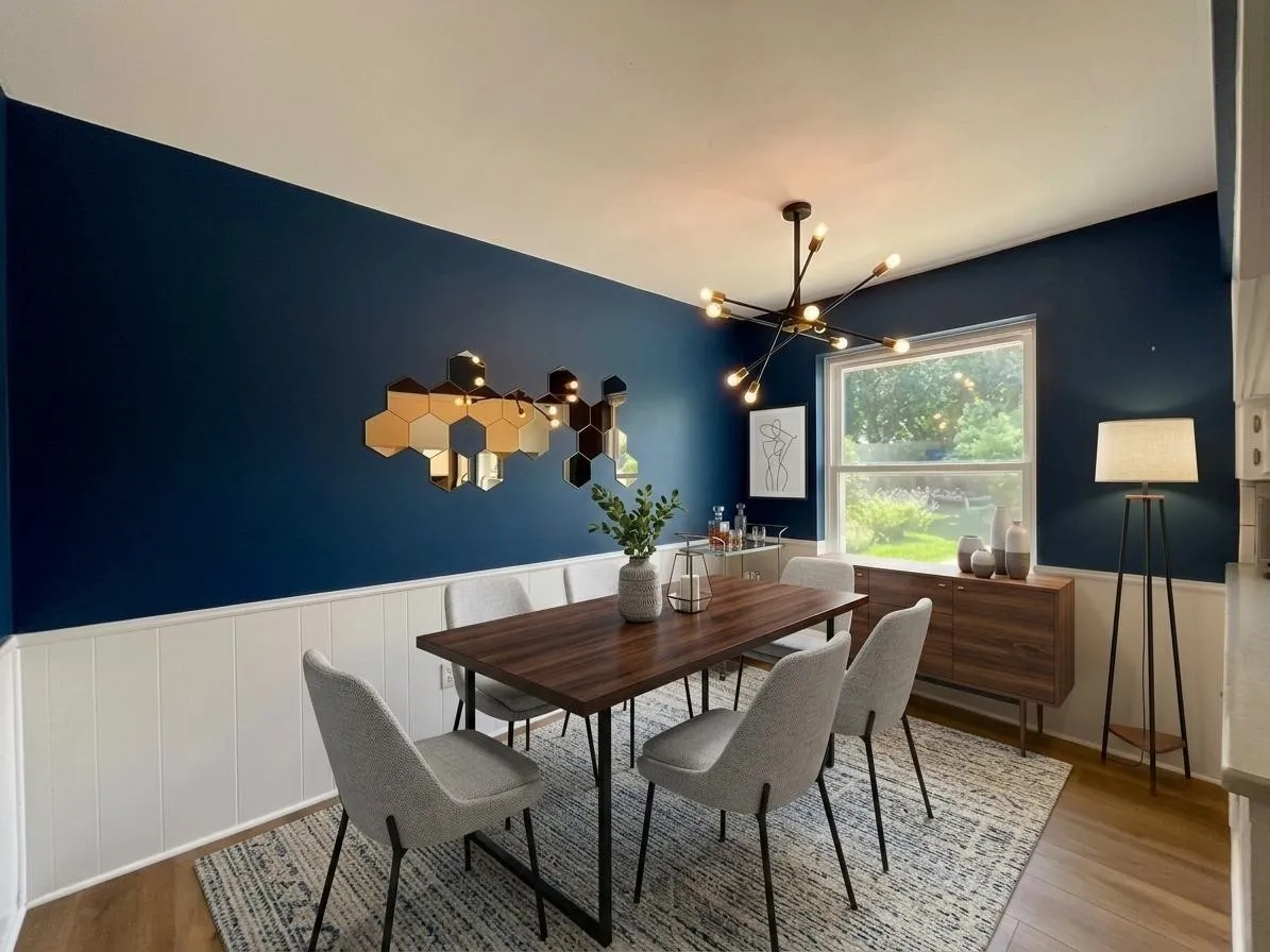 Dining area featuring wood-finish flooring, white wainscoting, and a prominent window