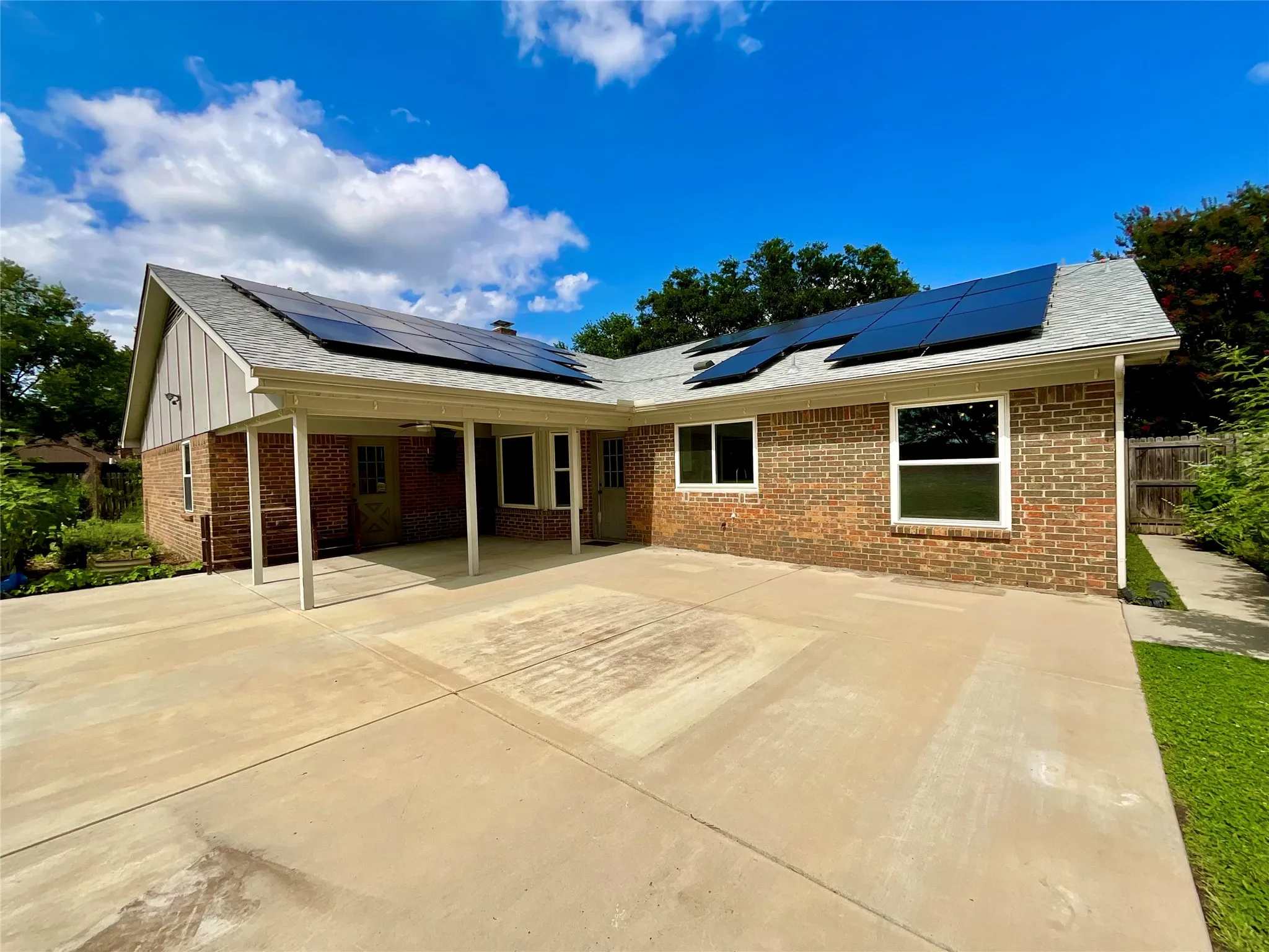 Red brick exterior with white trim and a covered patio area