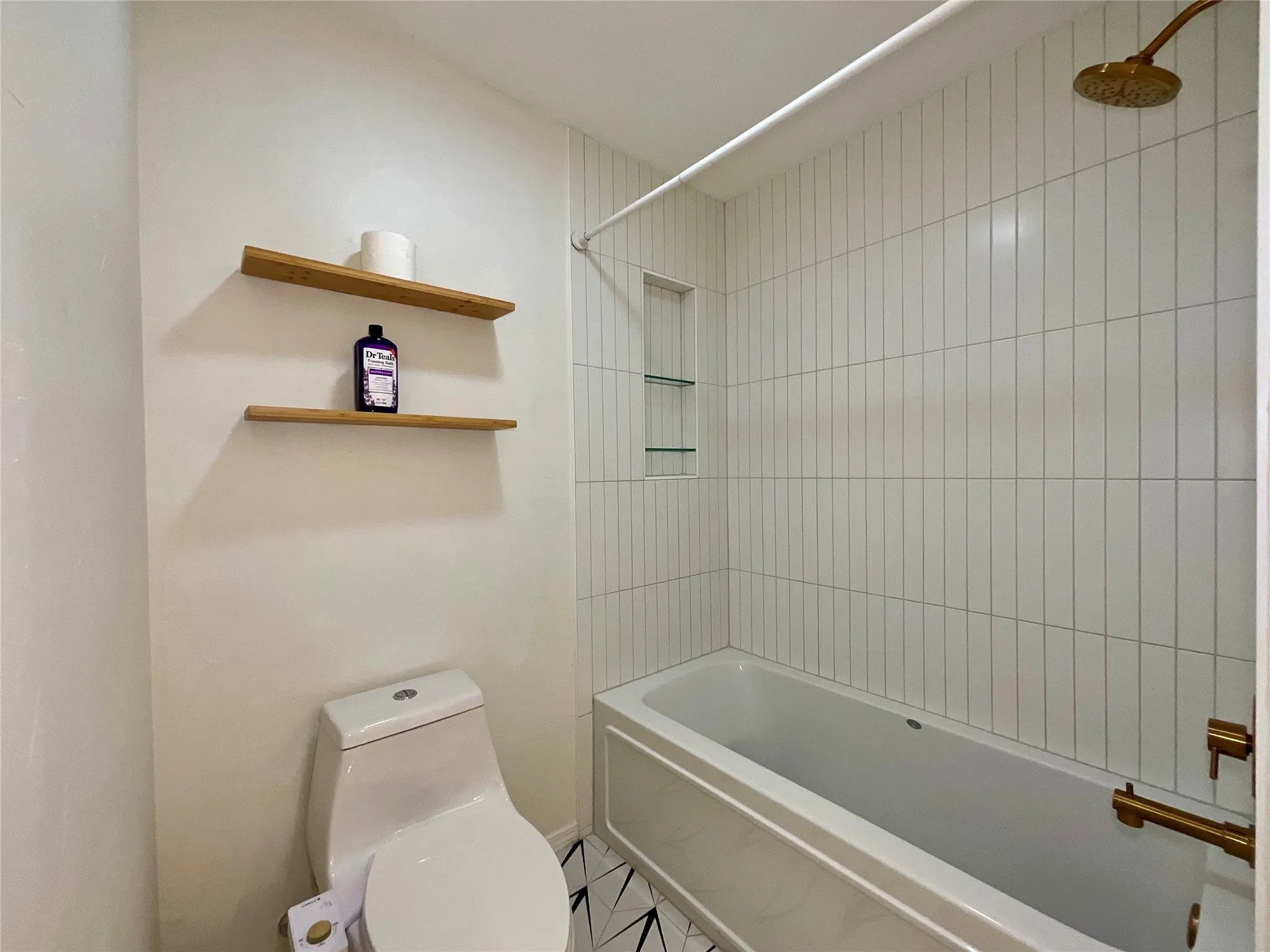 Tub and shower combination featuring vertical white subway tile