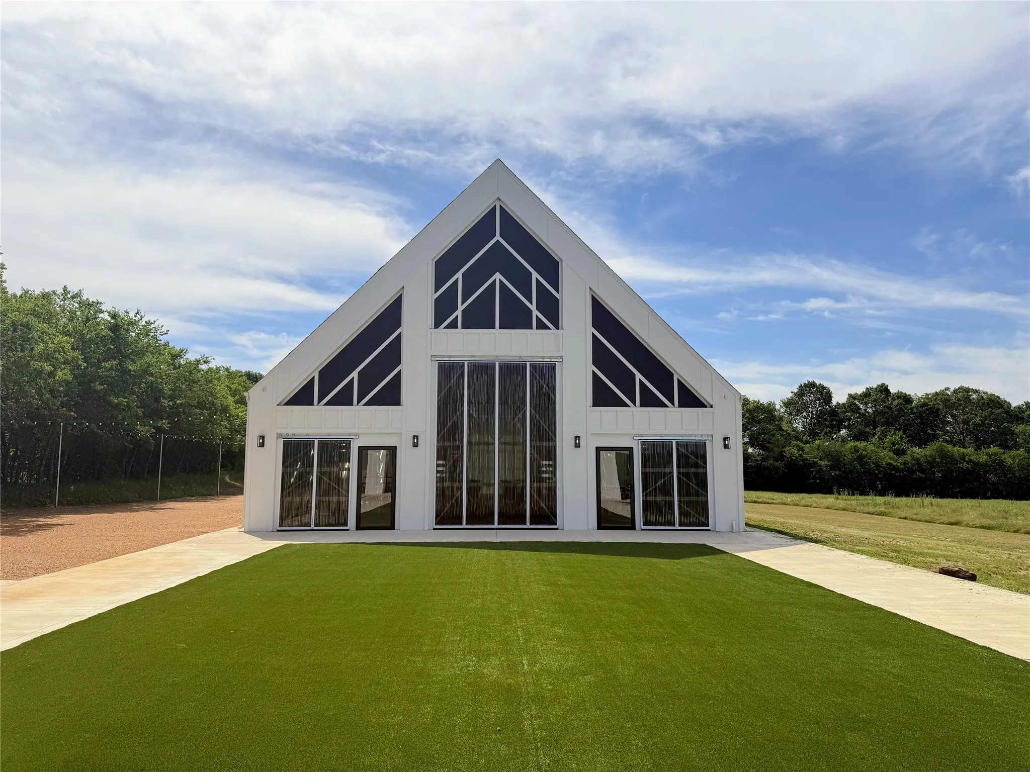 Modern barn-style structure featuring a white exterior with black trim
