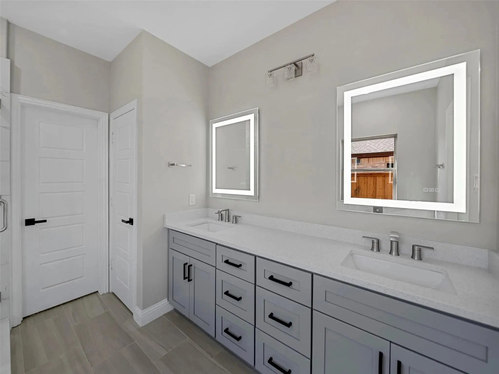 Dual vanity with light gray cabinetry, white countertops, and integrated sinks