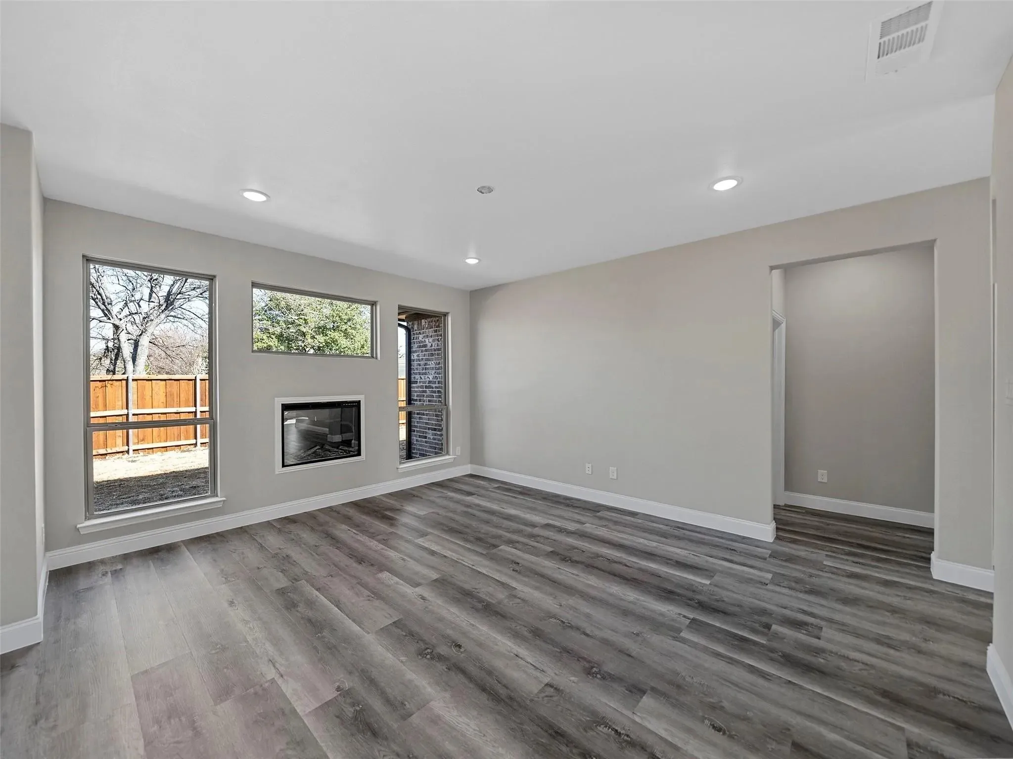 Living area featuring wood-finish flooring and recessed lighting