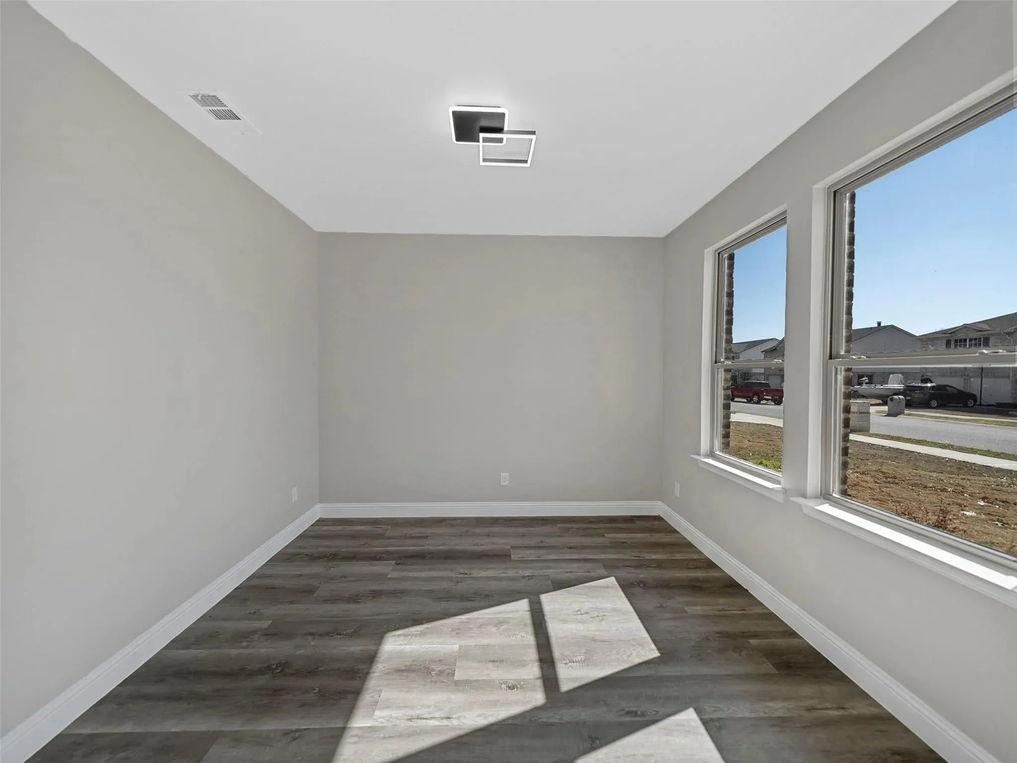 Bright interior space featuring light gray walls and wood-finish flooring