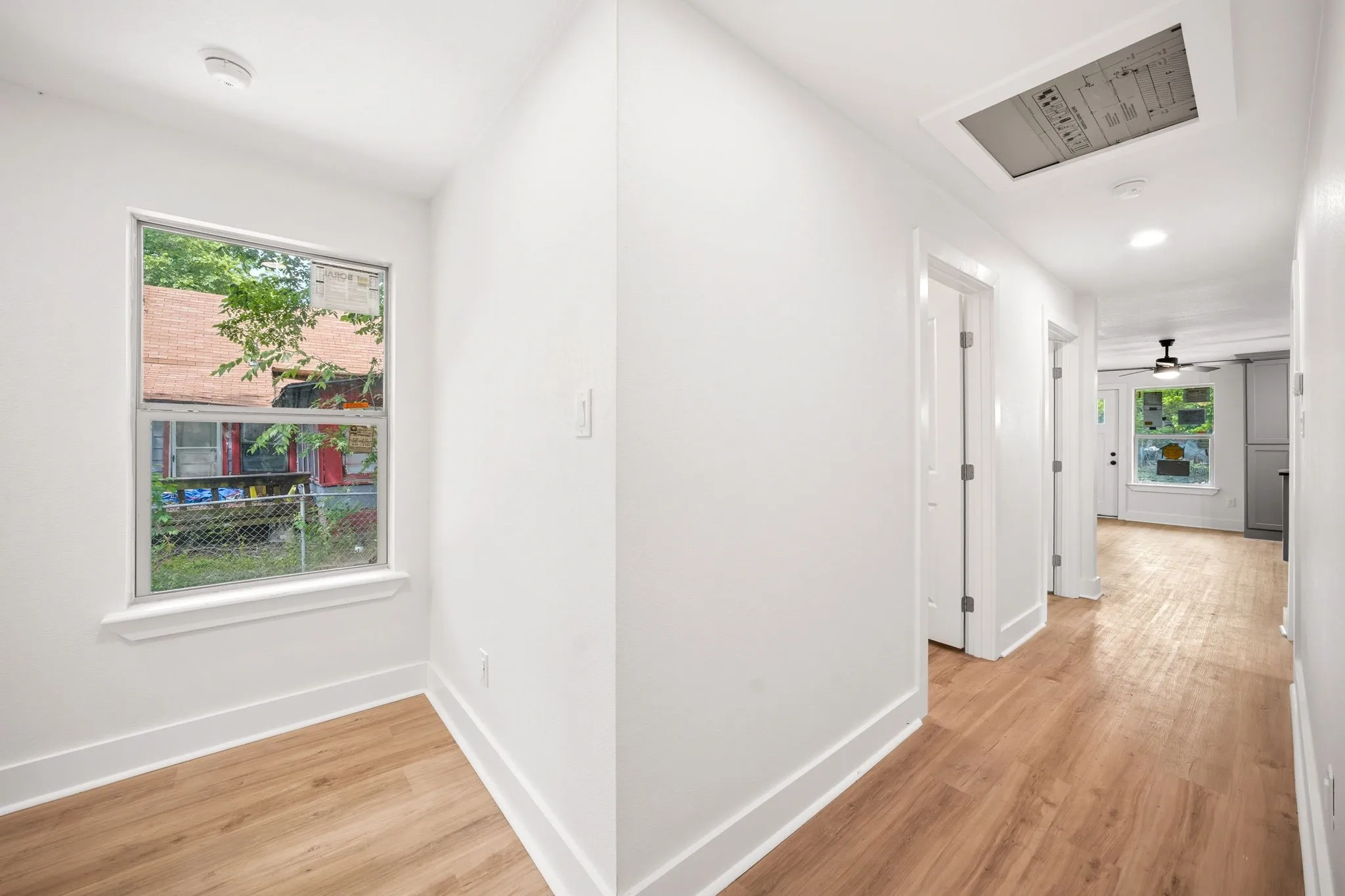 Hallway featuring wood-finish flooring, recessed lighting, and white trim