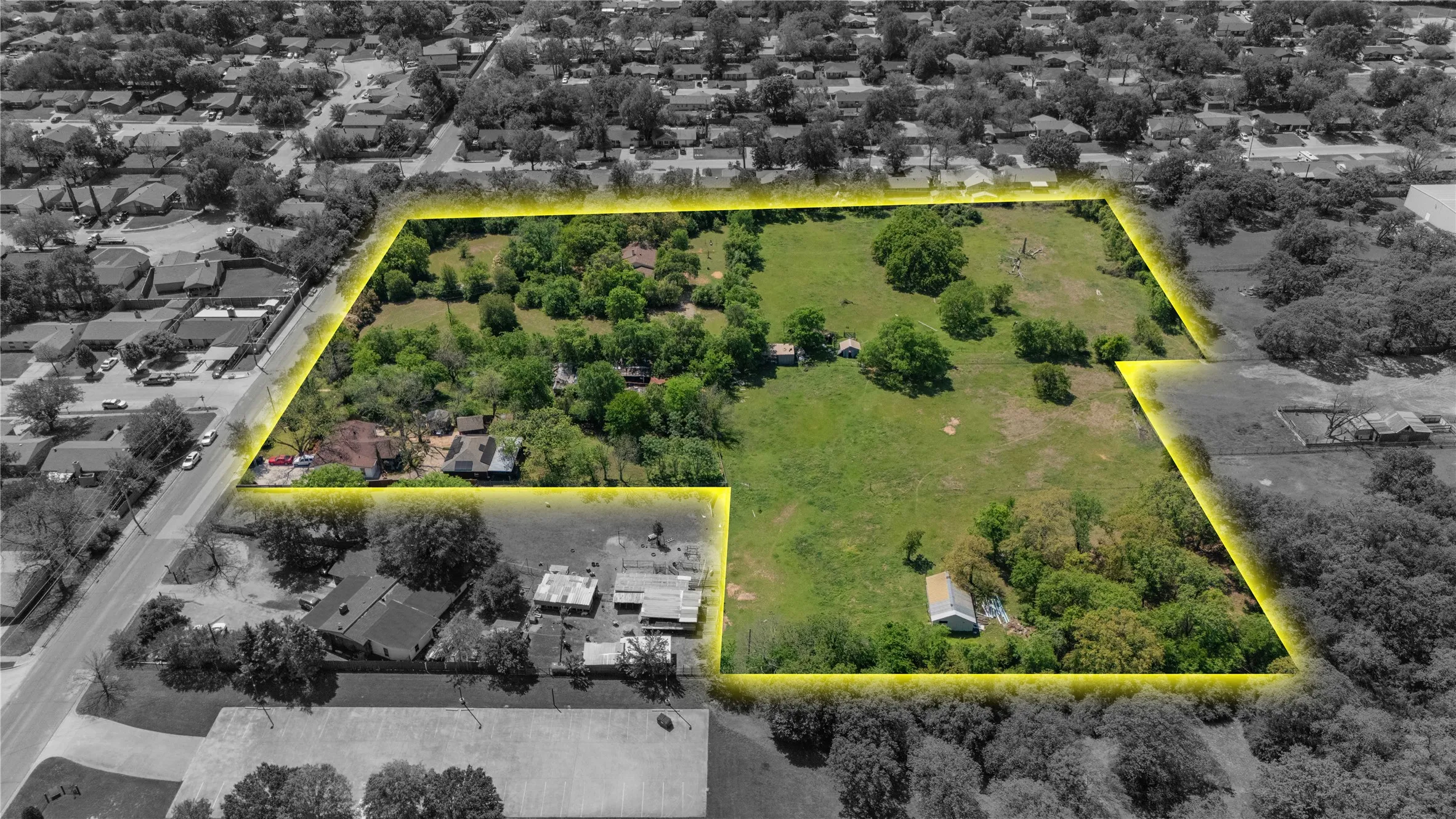 Expansive land parcel featuring a combination of open fields and mature tree coverage