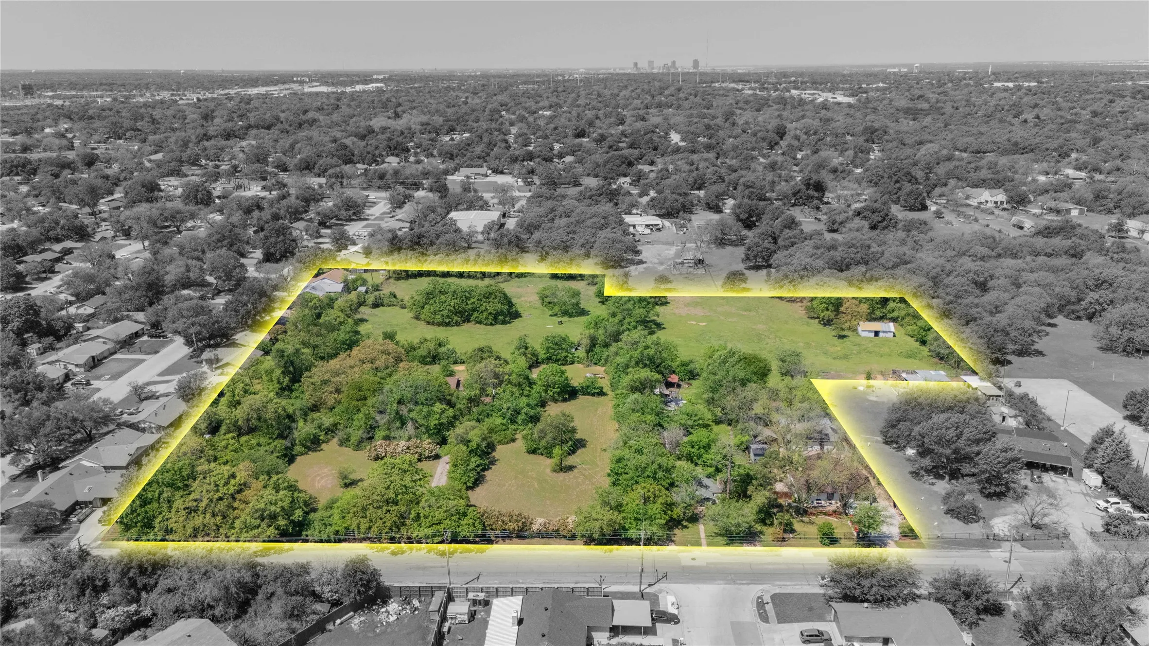Expansive land parcel featuring substantial tree coverage and a partially cleared area