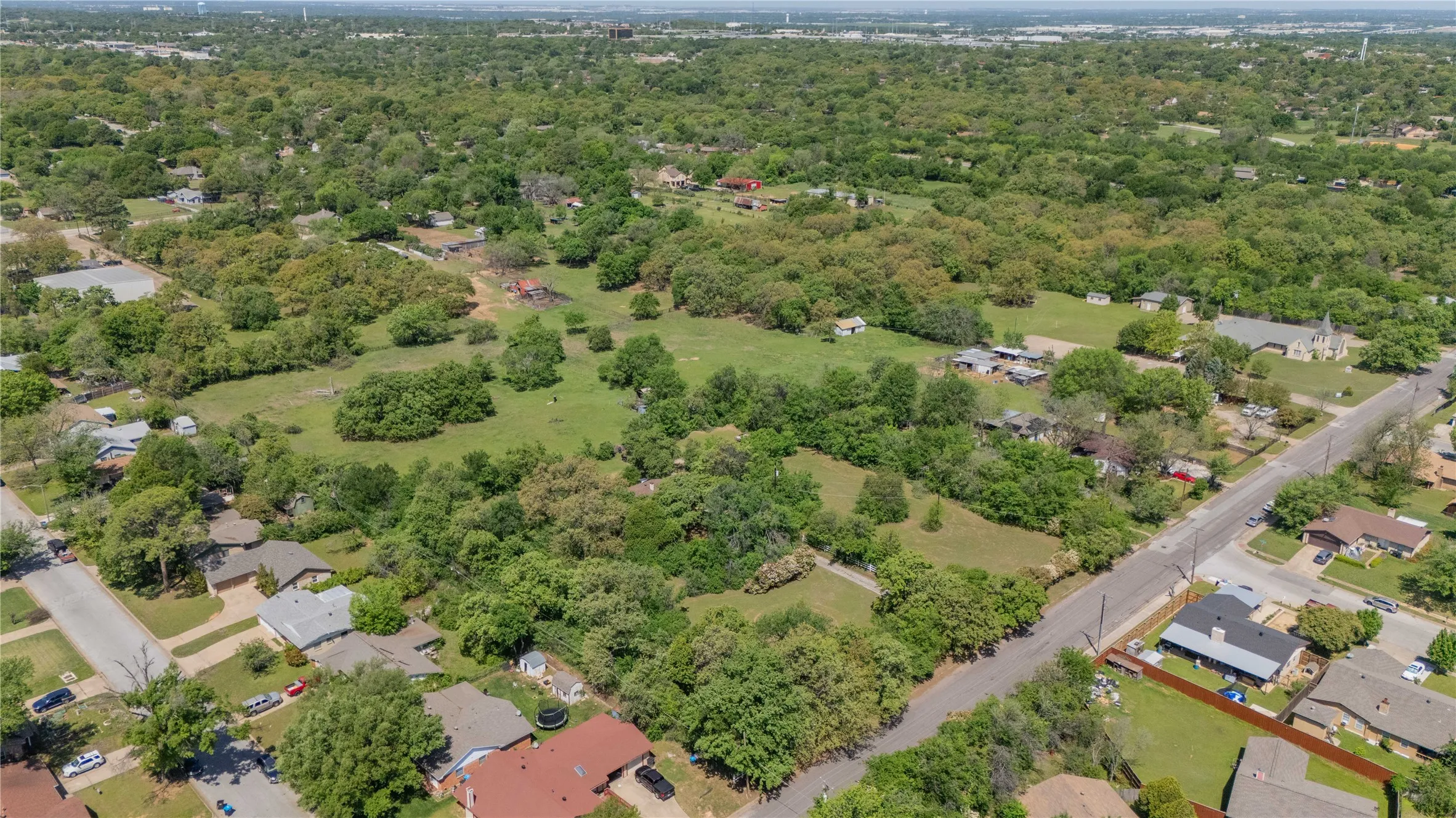Expansive residential area featuring a verdant landscape with abundant mature trees and open green spaces