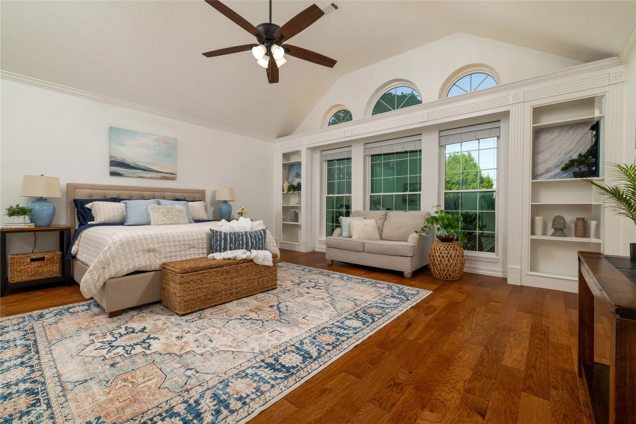 An alcove leads from the living room to the owners suite. Note the wall of windows with custom built-ins.