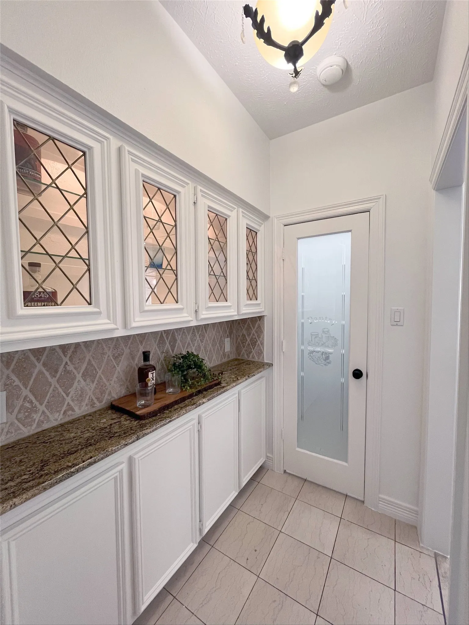 The lighted butler's pantry features a walk-in pantry and leads into the kitchen