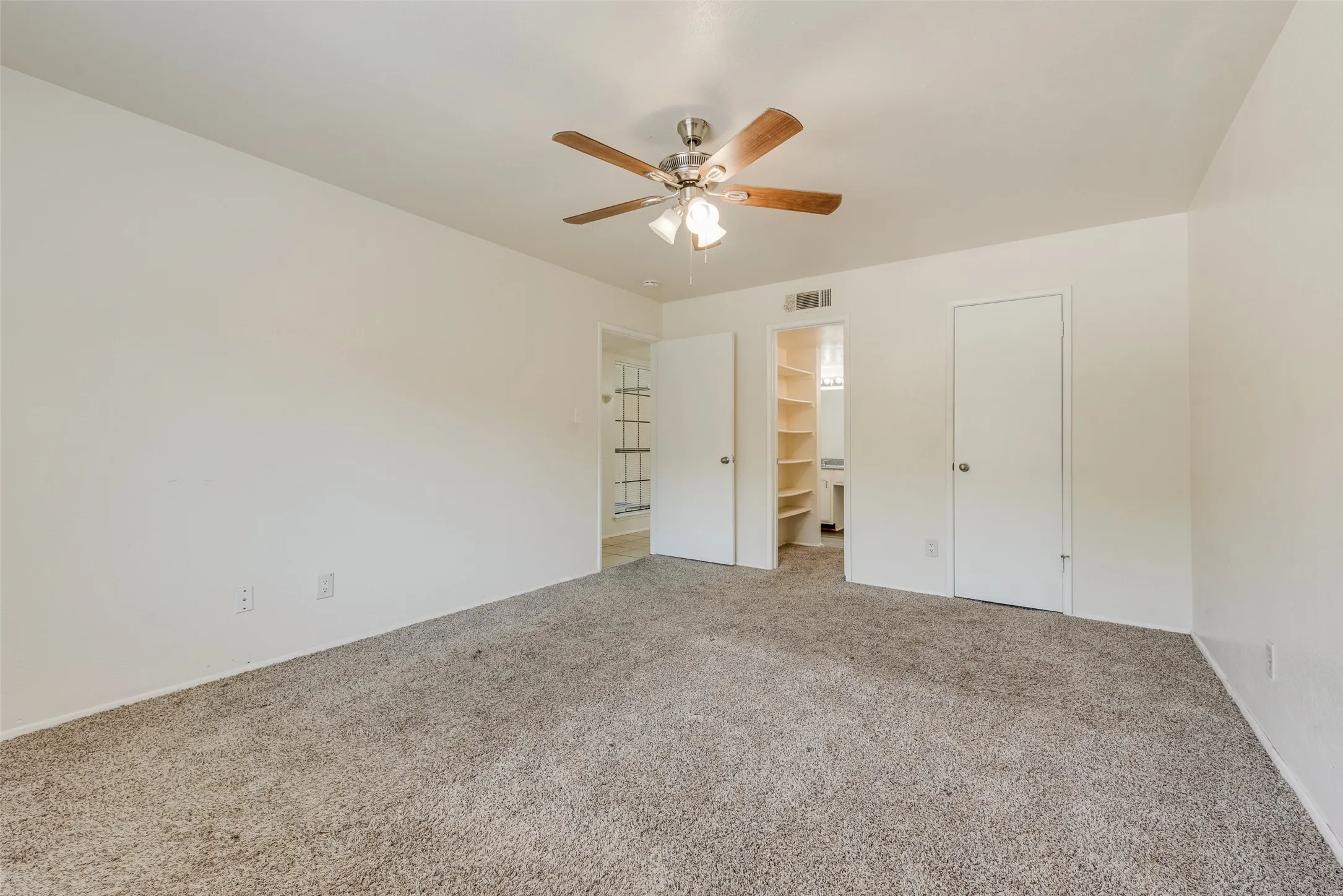 Spacious room featuring neutral carpeting and light-colored walls