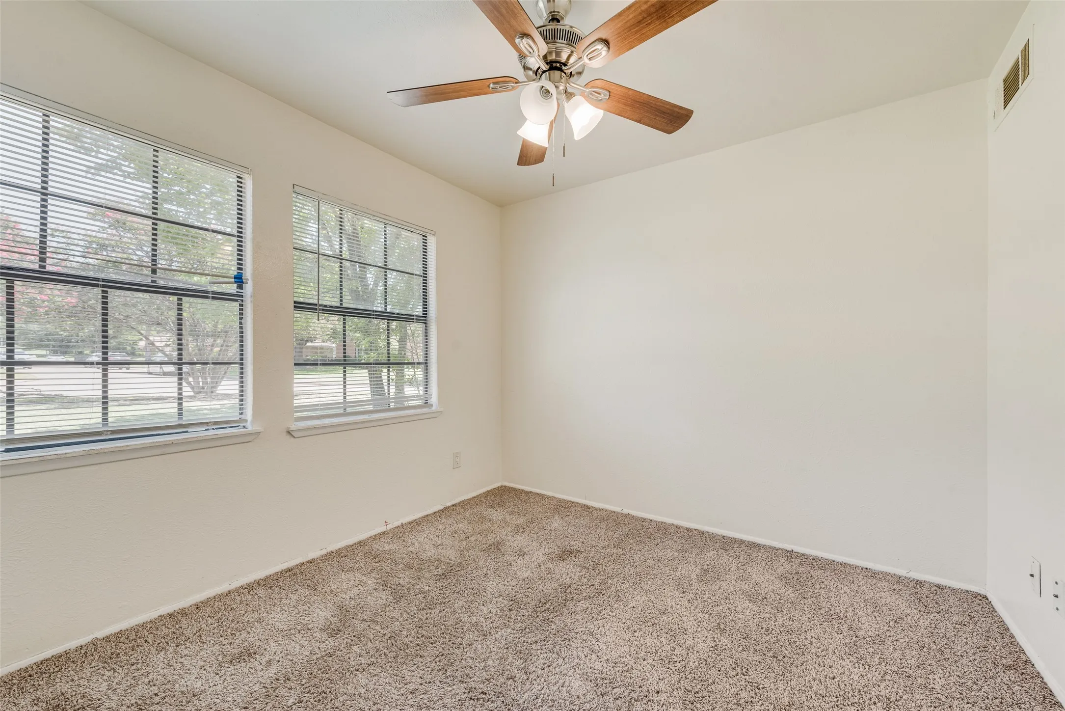 Room featuring light-toned walls and neutral carpet flooring