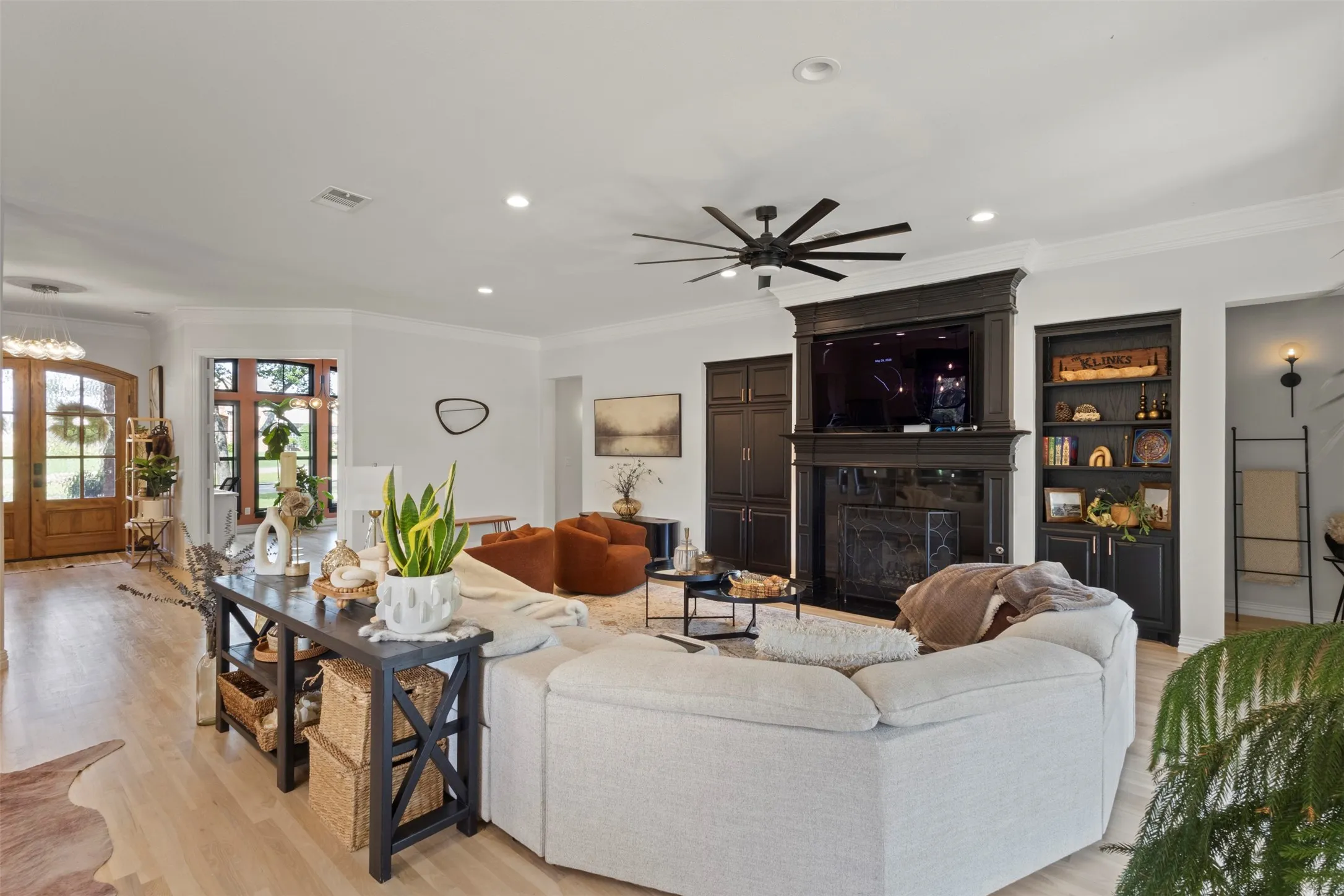 Luxury living room showcasing custom black built-ins, a statement fireplace, designer lighting, white oak flooring, and refined finishes—creating an elevated yet inviting space perfect for upscale entertaining and everyday comfort.