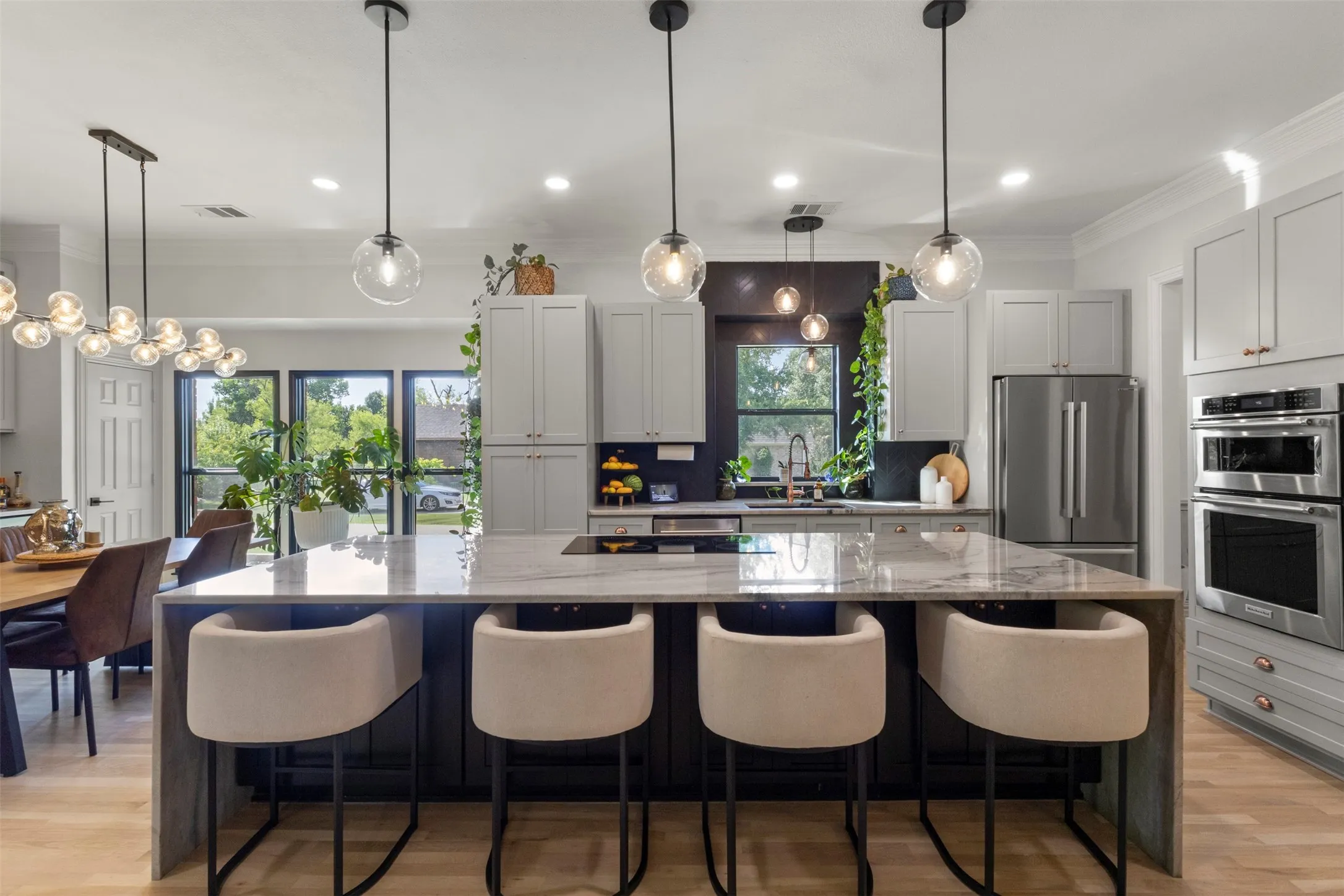 Designer kitchen and bar upgrades with custom cabinetry, copper accents, updated appliances, and premium stone selections, including Aquarela quartzite