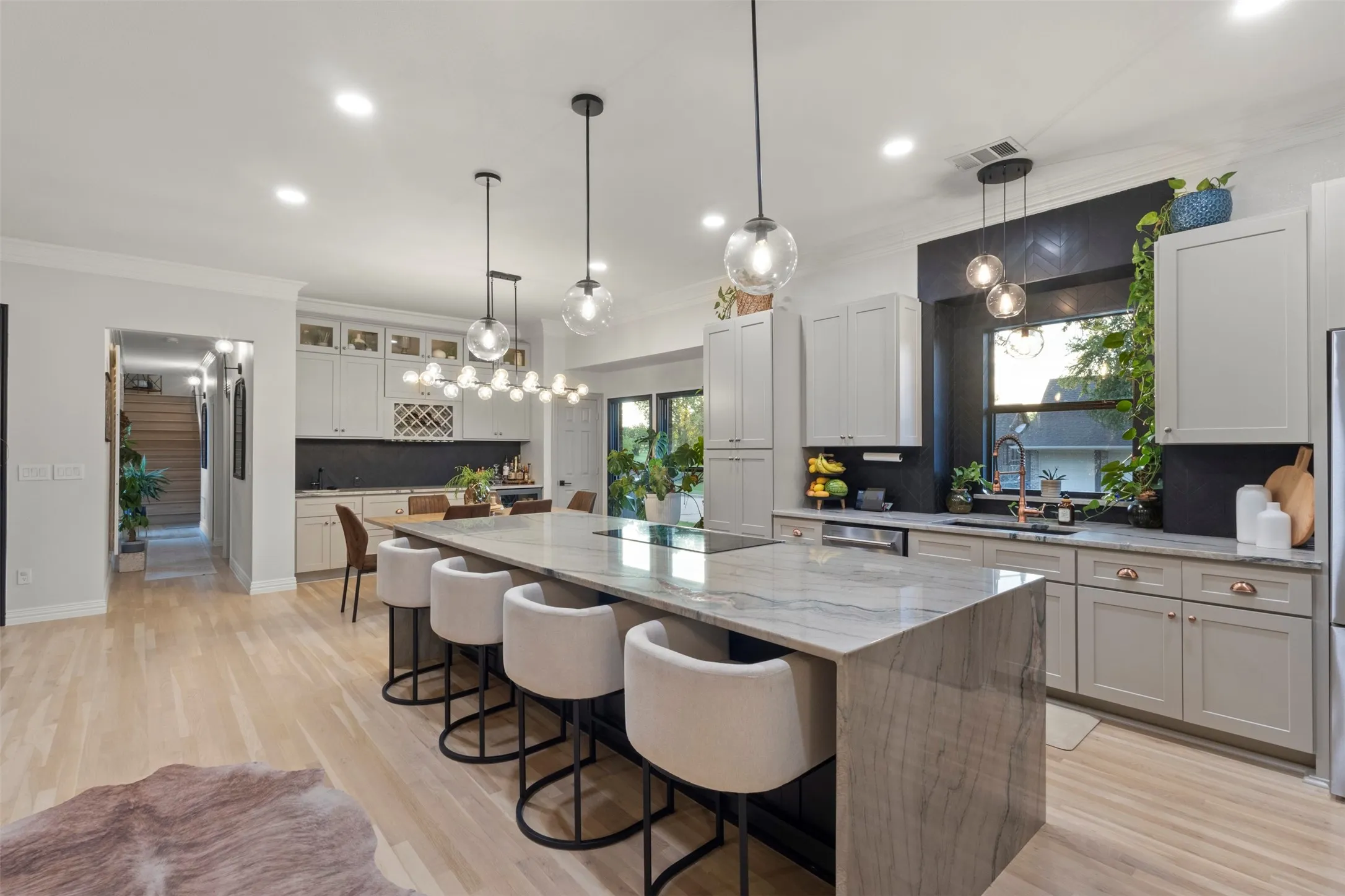 Designer kitchen and bar upgrades with custom cabinetry, copper accents, updated appliances, and premium stone selections, including Aquarela quartzite