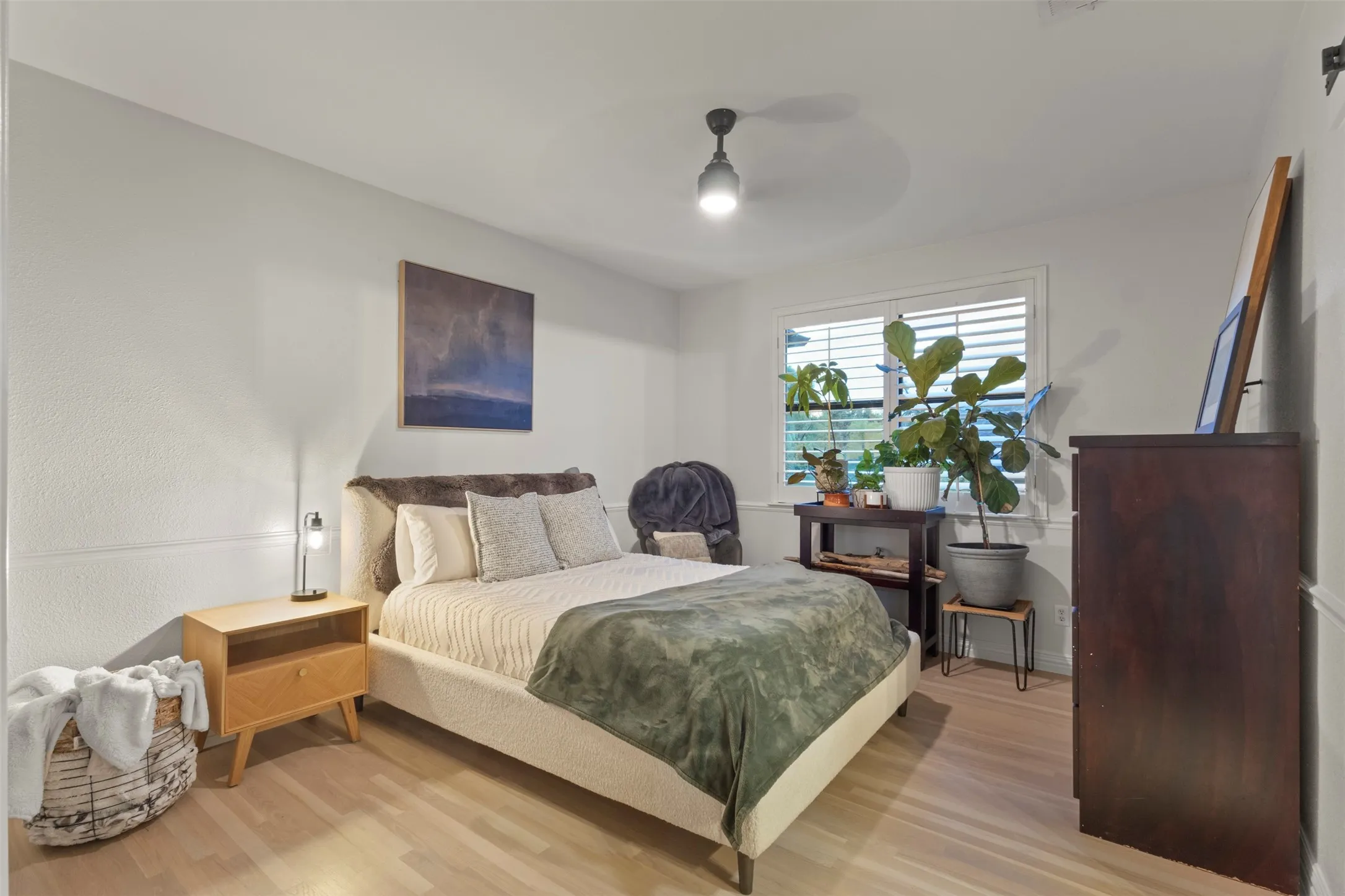 Inviting guest room featuring soft neutral finishes, updated trim details, natural light, and replaced white oak hardwood flooring—creating a comfortable, elevated retreat for overnight guests.