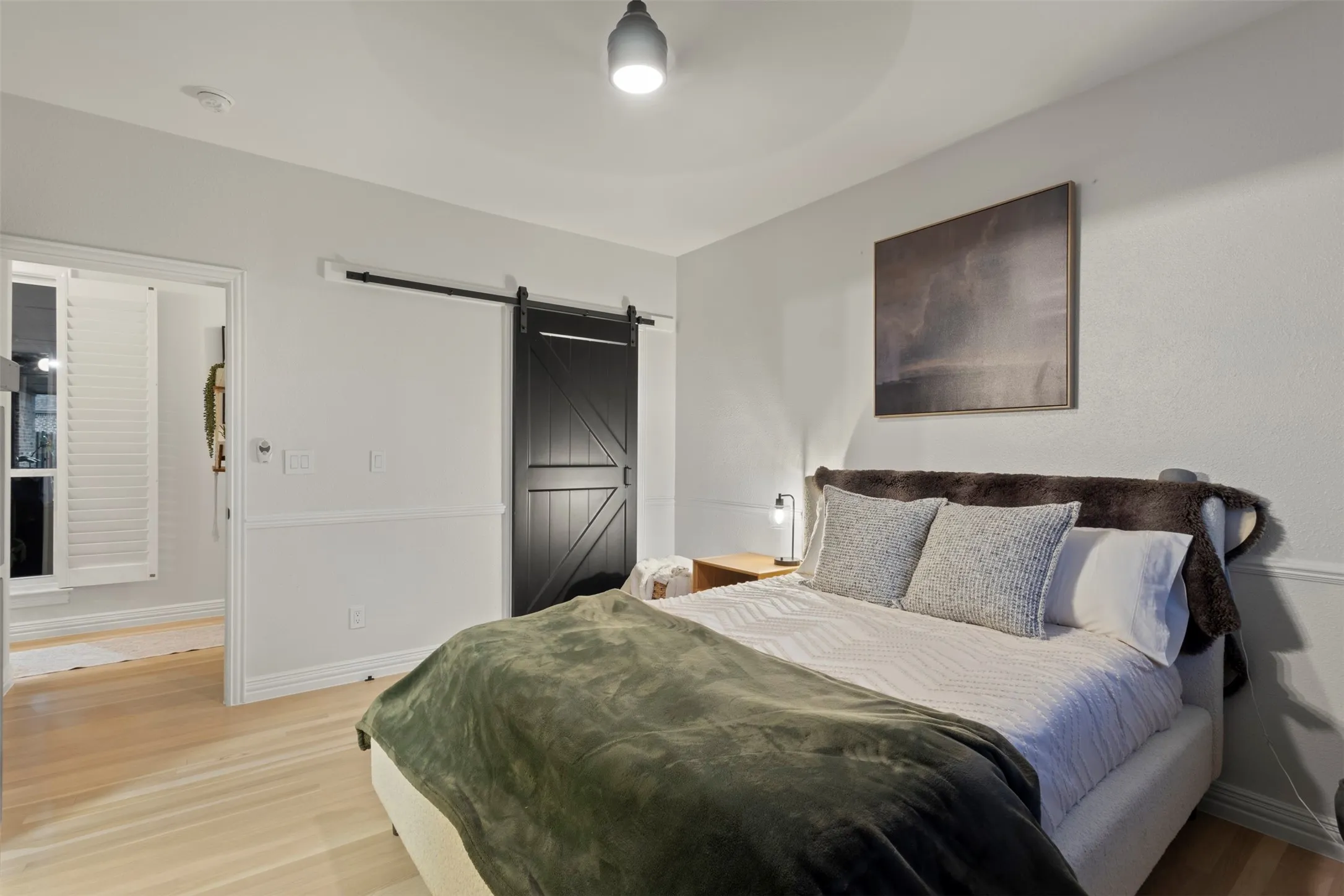 Inviting guest room featuring soft neutral finishes, updated trim details, natural light, and replaced white oak hardwood flooring—creating a comfortable, elevated retreat for overnight guests.