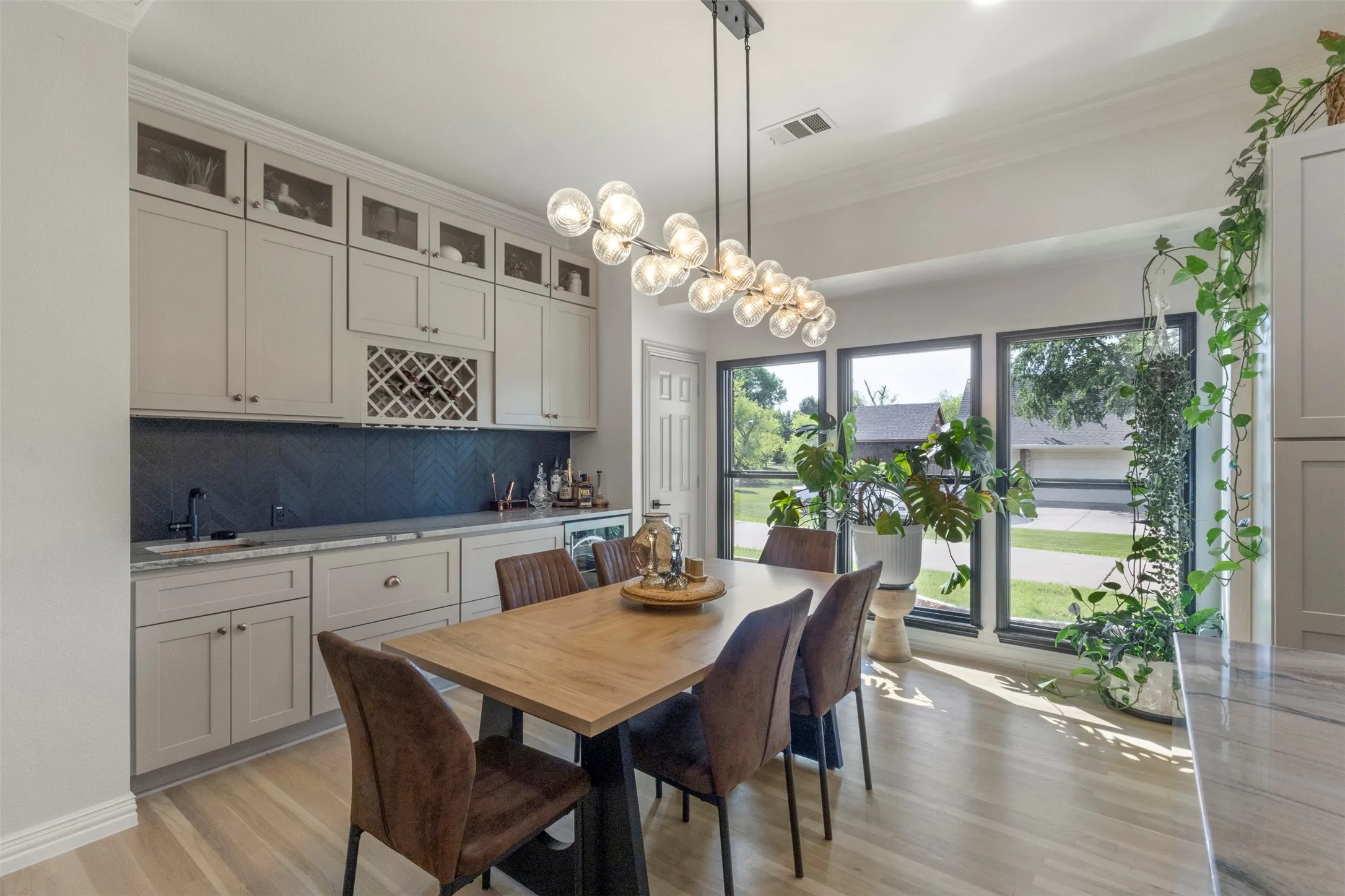 Elegant eat-in kitchen featuring statement designer lighting