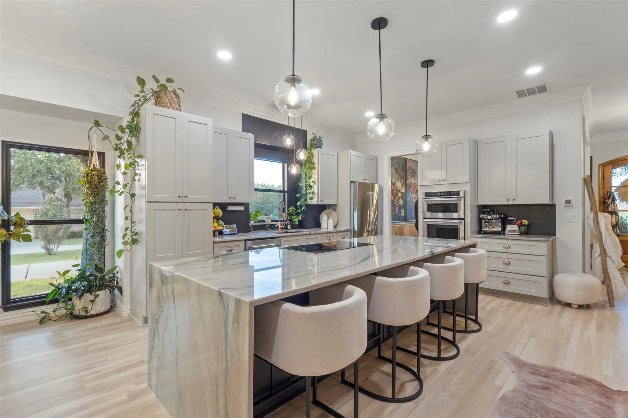 Designer kitchen and bar upgrades with custom cabinetry, copper accents, updated appliances, and premium stone selections, including Aquarela quartzite