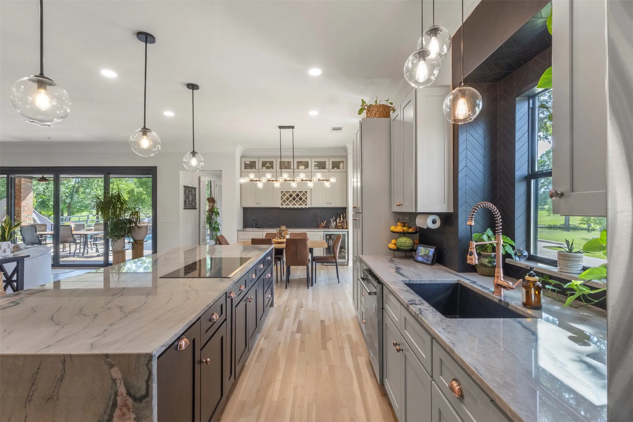 Designer kitchen and bar upgrades with custom cabinetry, copper accents, updated appliances, and premium stone selections, including Aquarela quartzite