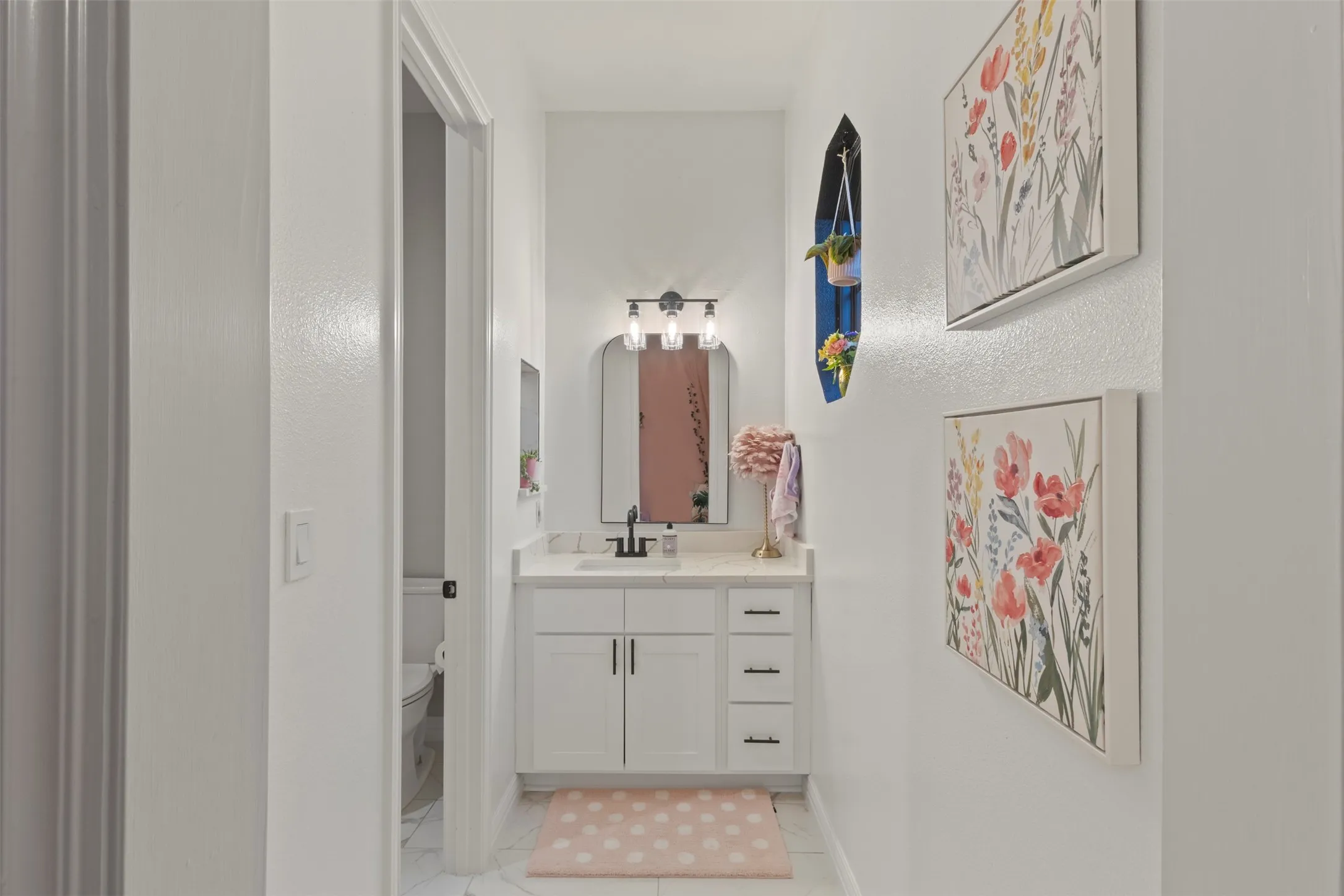 Fully renovated Jack-and-Jill bathroom featuring custom cabinetry, Calacatta quartz countertops, matte black hardware, new bathtub, and updated tile on the shower walls and flooring for a clean, elevated designer finish.