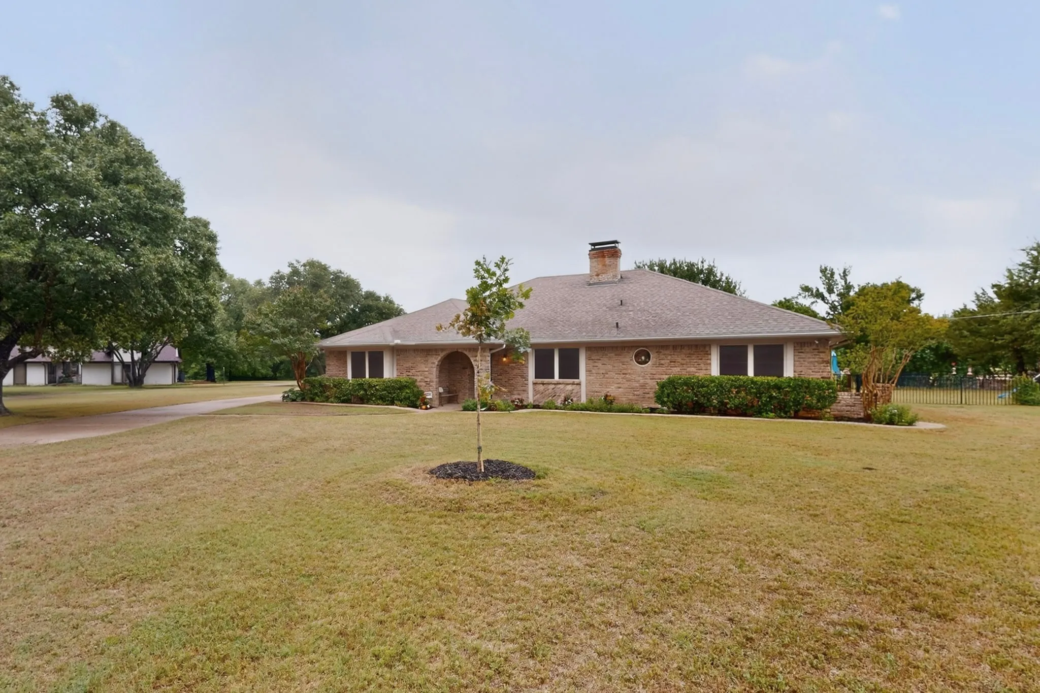 Brick exterior residence with an arched entry, and chimney