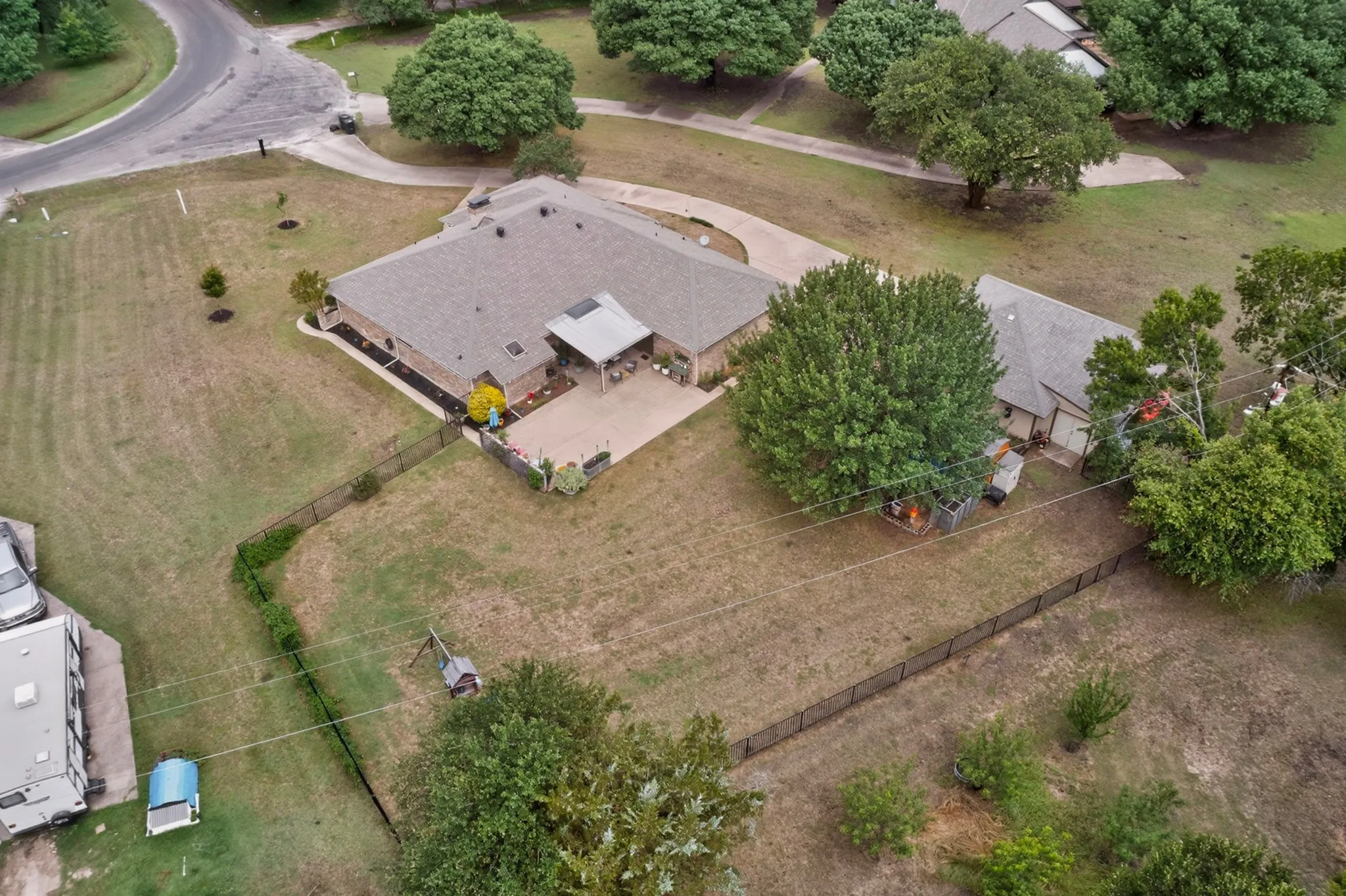 Expansive property featuring a single-story residence with a covered patio, a detached auxiliary structure, and a fenced perimeter
