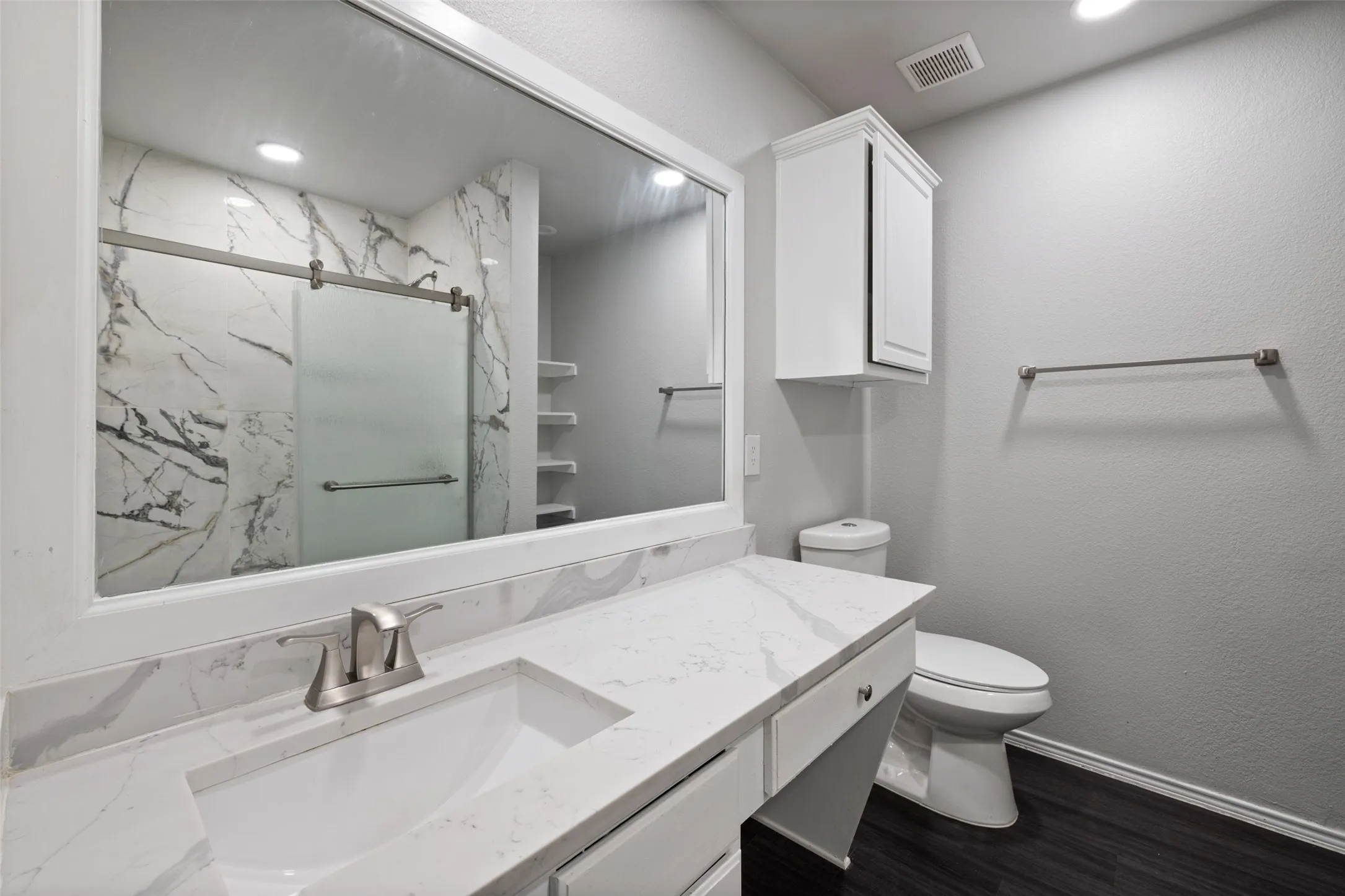 Bathroom featuring hardwood / wood-style flooring, toilet, and large vanity