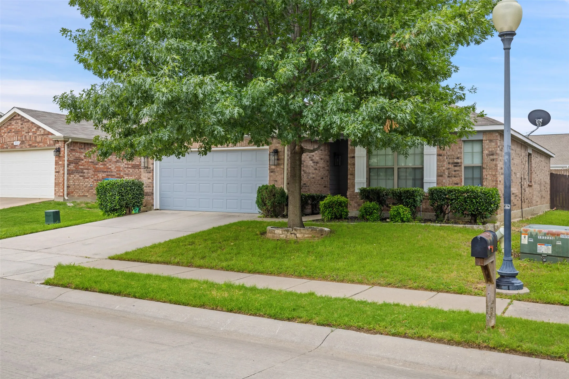 Obstructed view of property featuring a front lawn and a garage