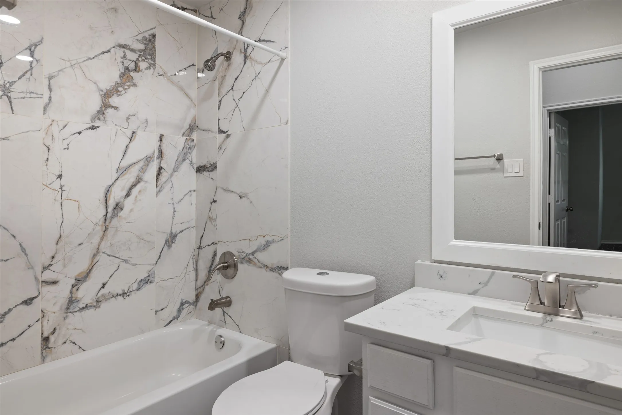 Full bathroom with tiled shower / bath, vanity, and toilet