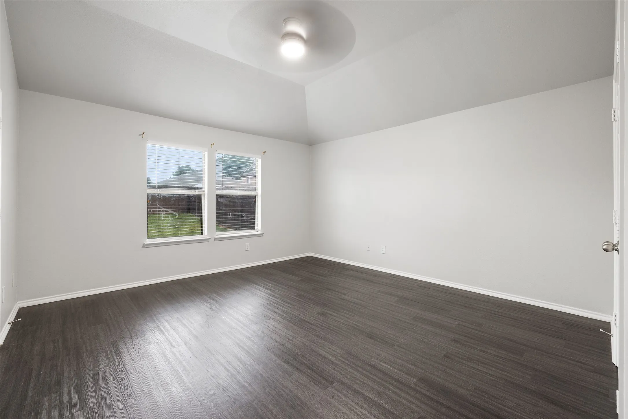 Unfurnished room featuring dark hardwood / wood-style floors and vaulted ceiling