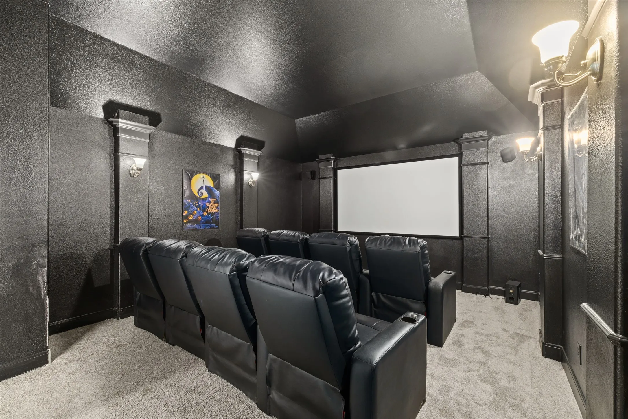 Carpeted home theater featuring decorative columns and lofted ceiling