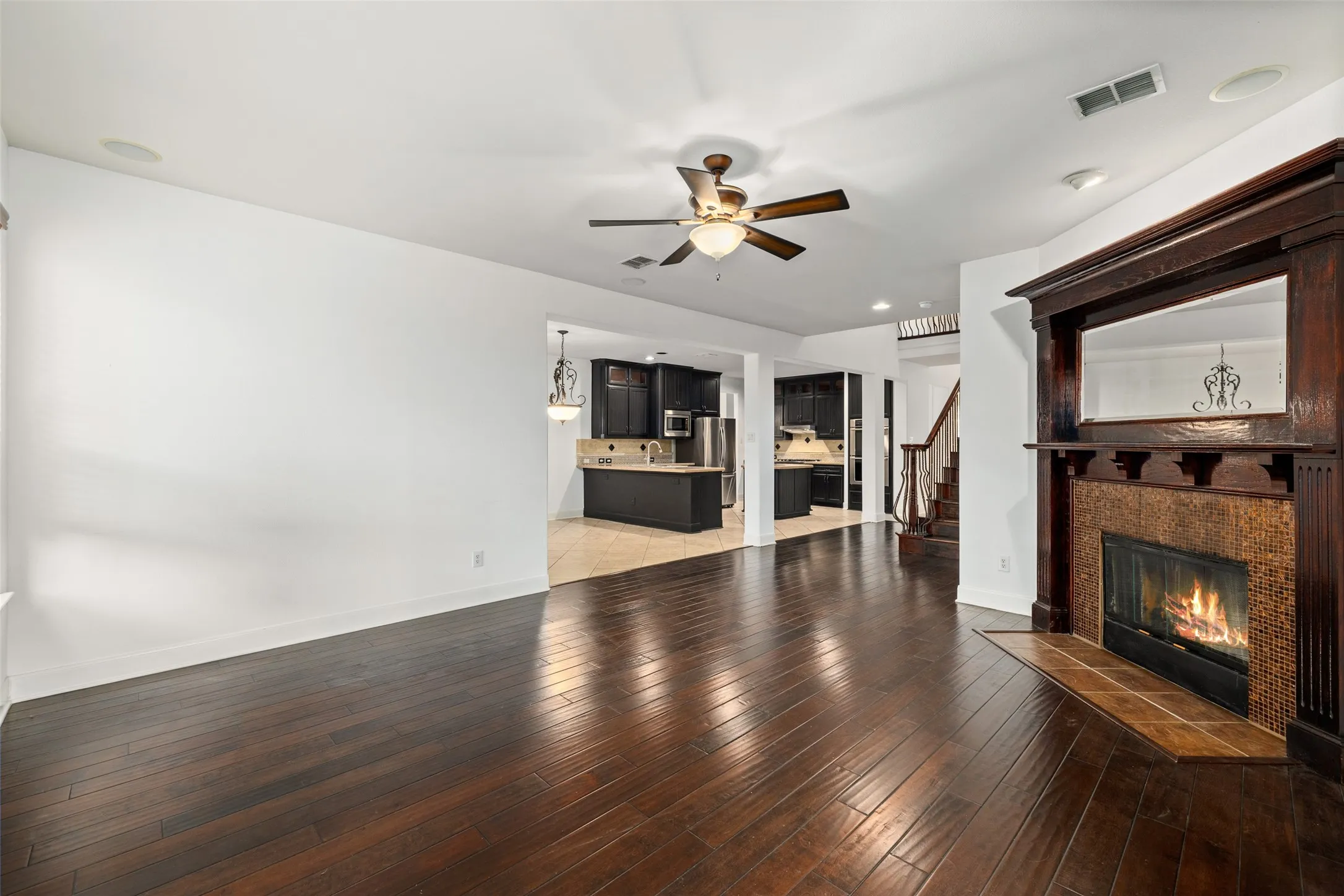 Unfurnished living room featuring a tiled fireplace, tile flooring, ceiling fan, and sink
