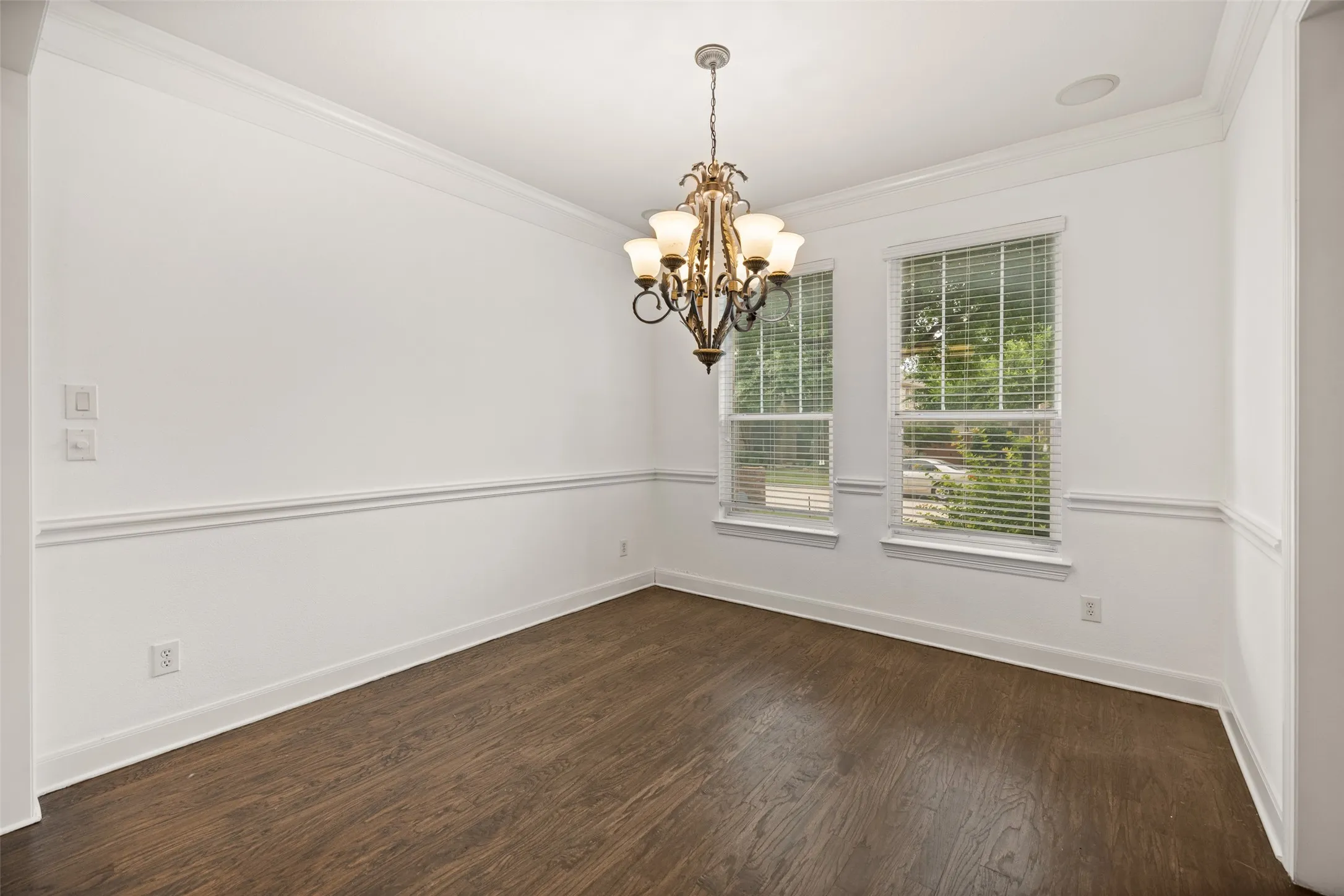 Dining room with crown molding, dark hardwood / wood-style floors, and a notable chandelier